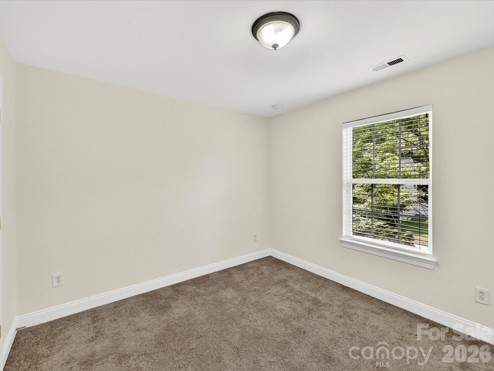 Well-proportioned secondary bedroom features a large closet, soft natural light, and a versatile layout ideal for family, guests, or a home workspace. - Cornelius