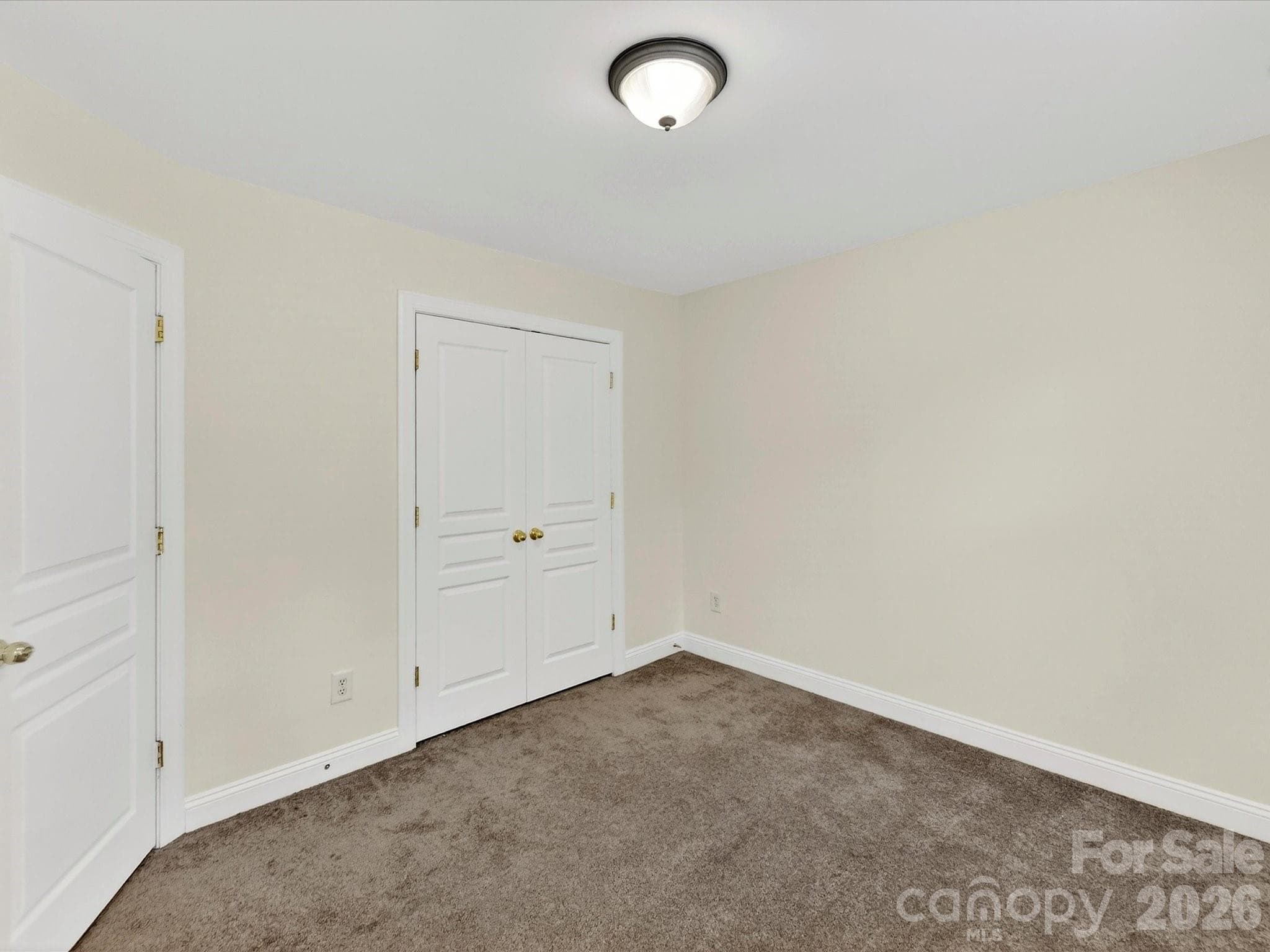 Well-proportioned secondary bedroom features a large closet, soft natural light, and a versatile layout ideal for family, guests, or a home workspace. - Cornelius