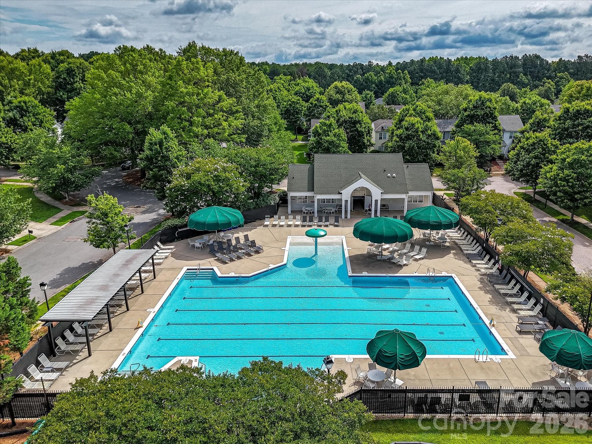 Residents enjoy access to a beautifully maintained community pool complex with expansive sun deck seating, a playground, and gathering spaces designed for recreation and relaxation. - Cornelius