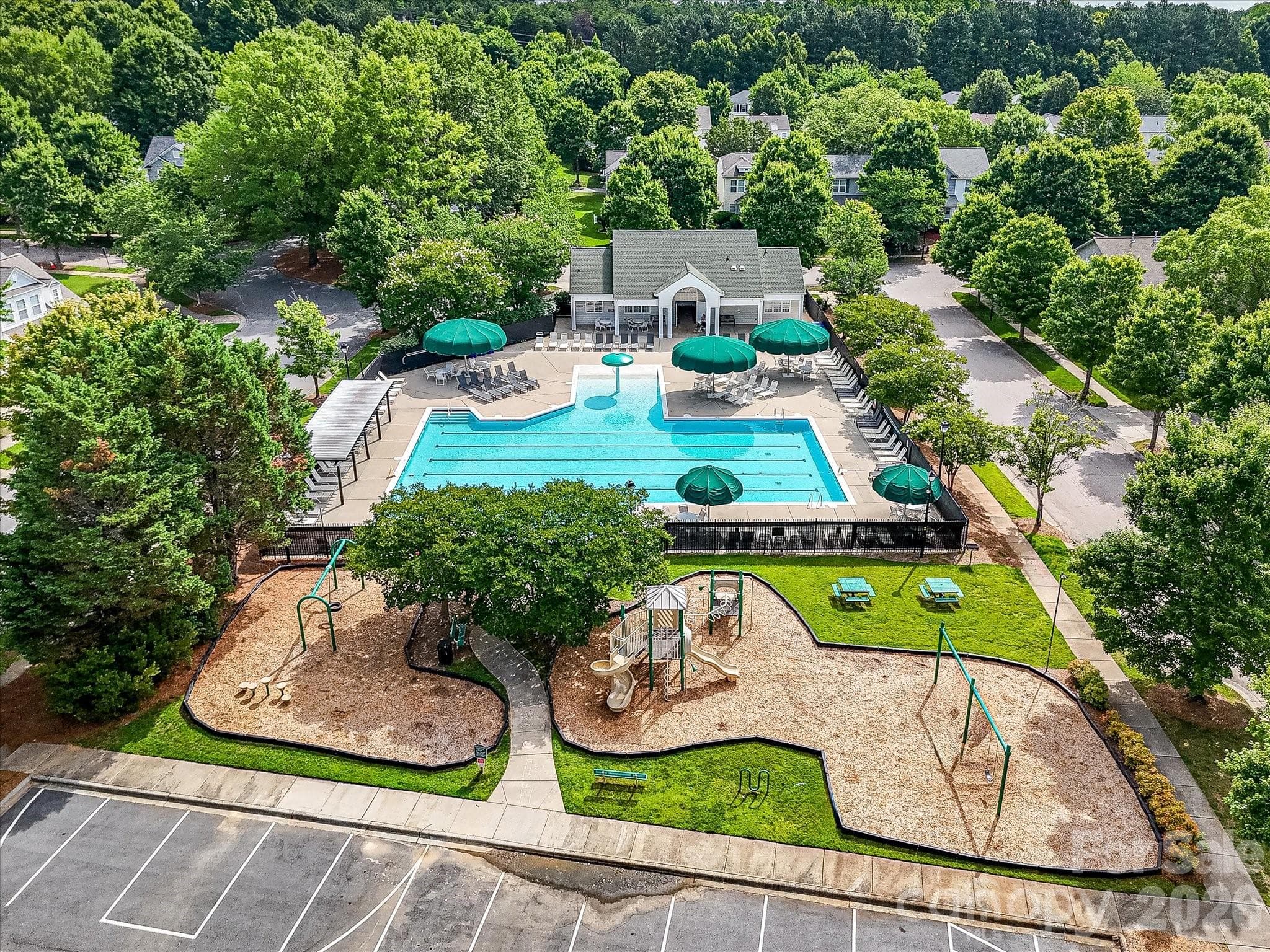 Residents enjoy access to a beautifully maintained community pool complex with expansive sun deck seating, a playground, and gathering spaces designed for recreation and relaxation. - Cornelius