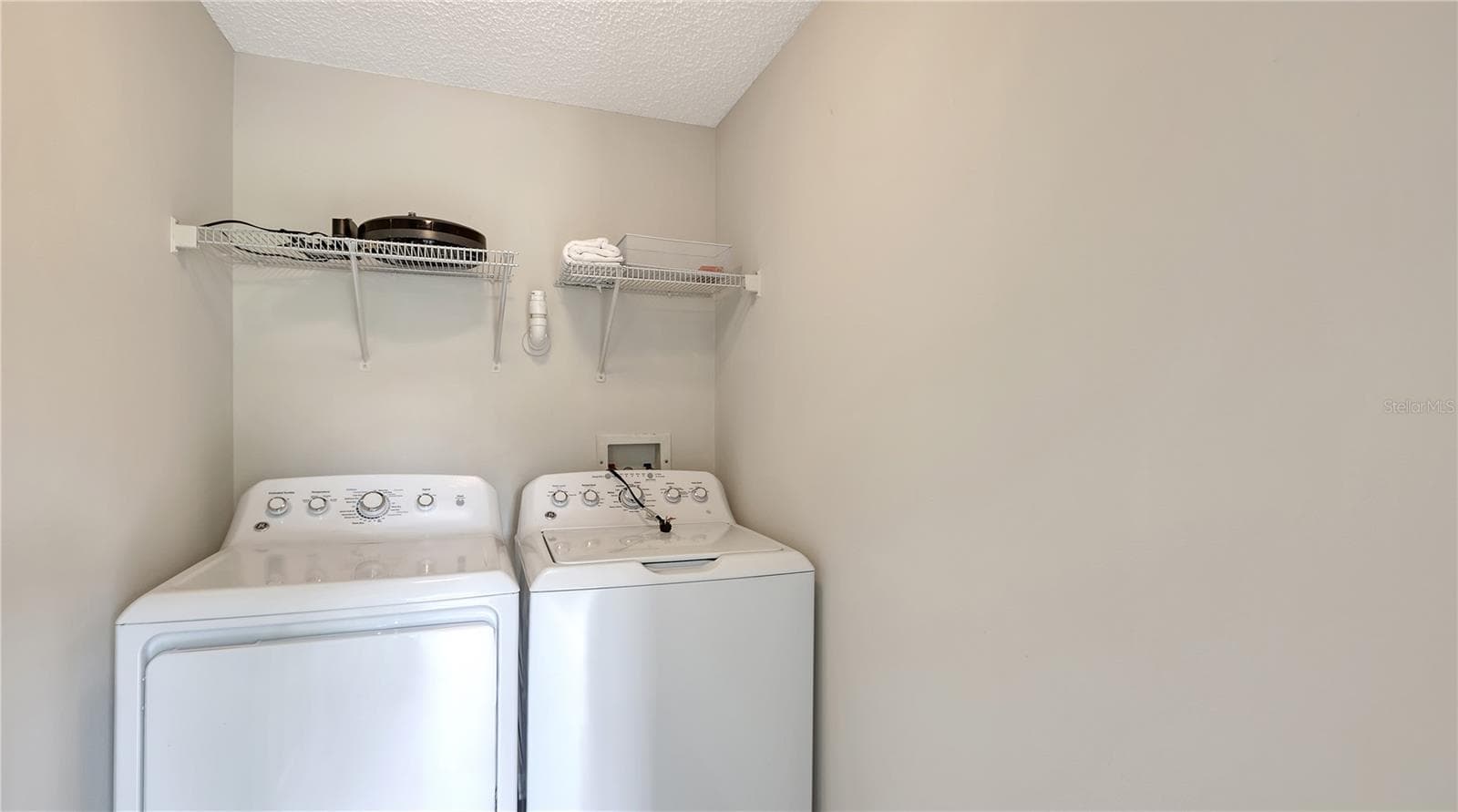 Laundry room with full-size laundry machine and a dryer. - 5551 BENTGRASS DR #11-117, SARASOTA