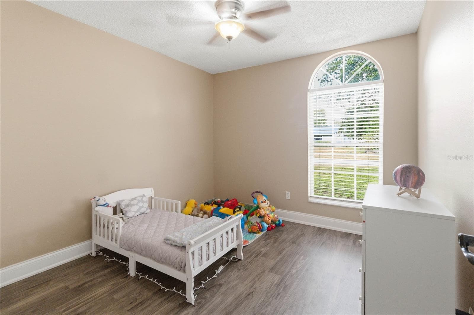 Bedroom 2 with arched window, ceiling fan and laminate flooring - 1564 CYPRESS WOODS CIR, ST CLOUD