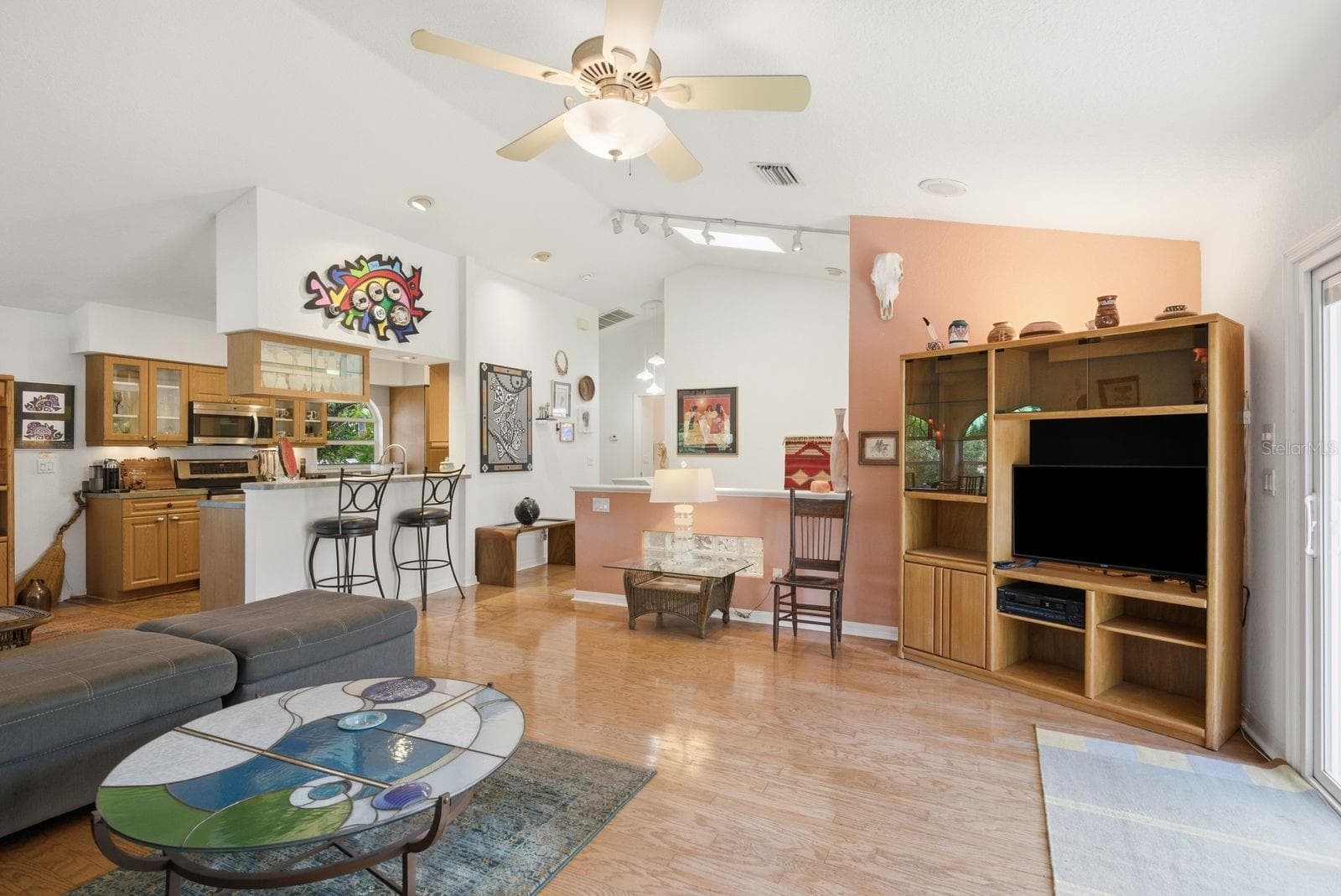 Living Room to kitchen and stairs with vaulted ceilings and skylight. - 755 SAN CHRISTOPHER DR, DUNEDIN