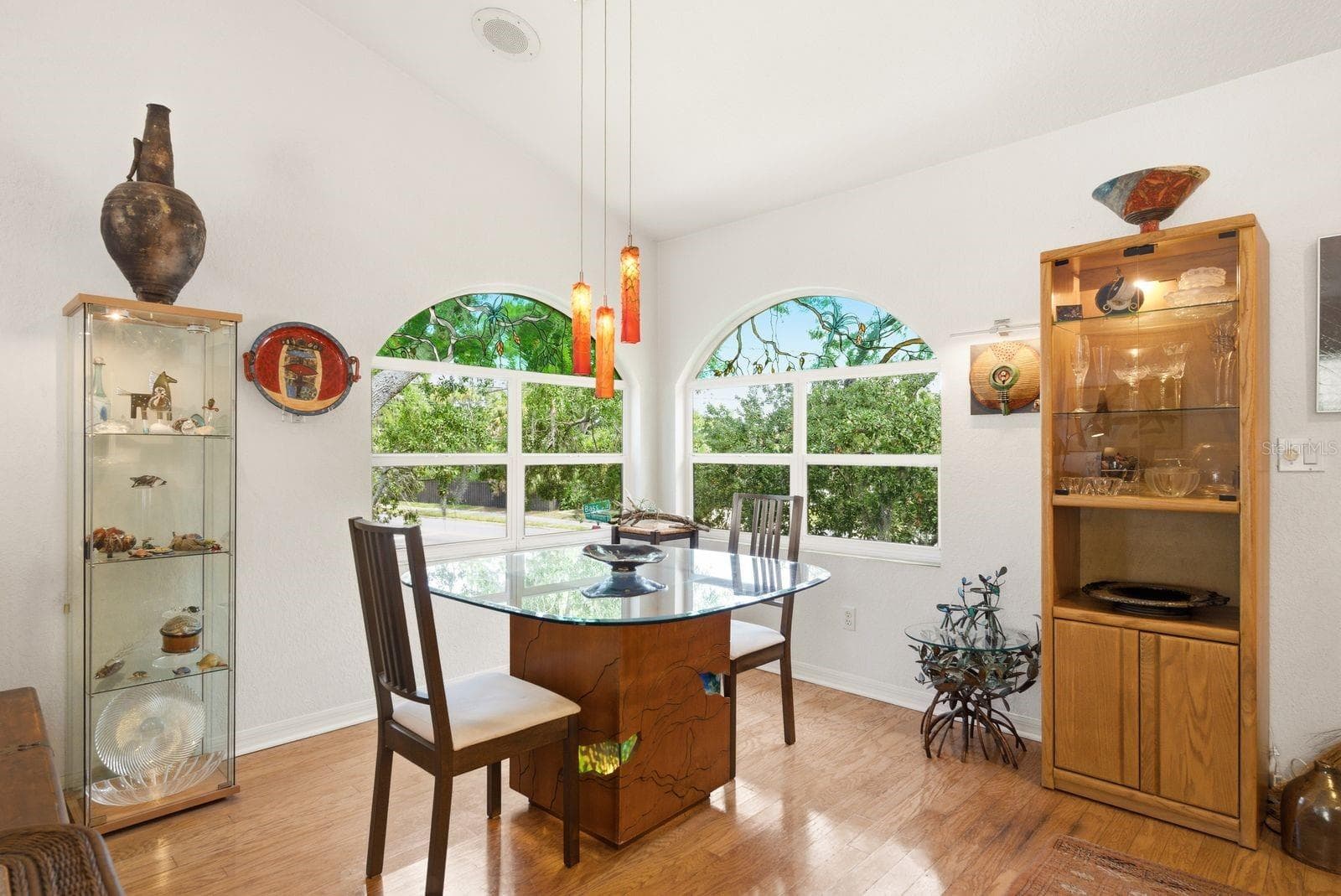Dining area overlooks front and side yard with custom windows, light fixture handmade by artist from Azerbaijan. - 755 SAN CHRISTOPHER DR, DUNEDIN