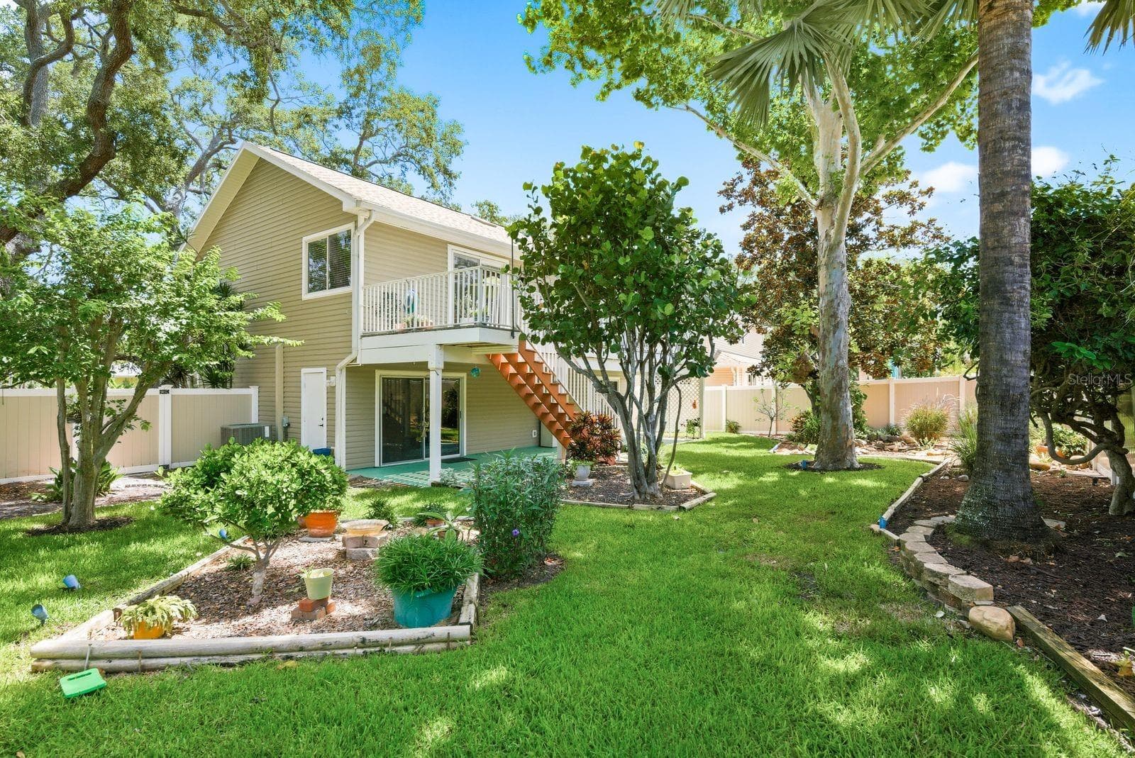 Garden with sycamore, florida wysteria, red maple, Palm tree, sea grape, hibiscus, frangipani & magnolia tree. - 755 SAN CHRISTOPHER DR, DUNEDIN