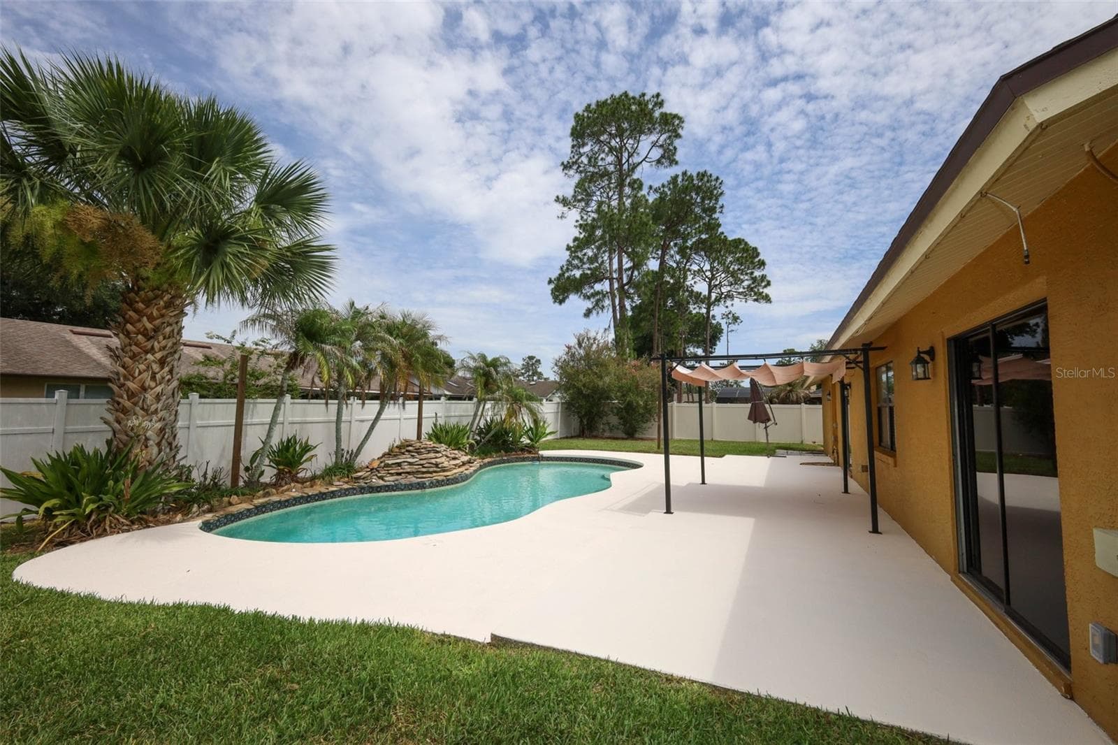 Rear yard with an open-air sparkling pool with space for the kids and pets to play. - 9110 PALM TREE DR, WINDERMERE