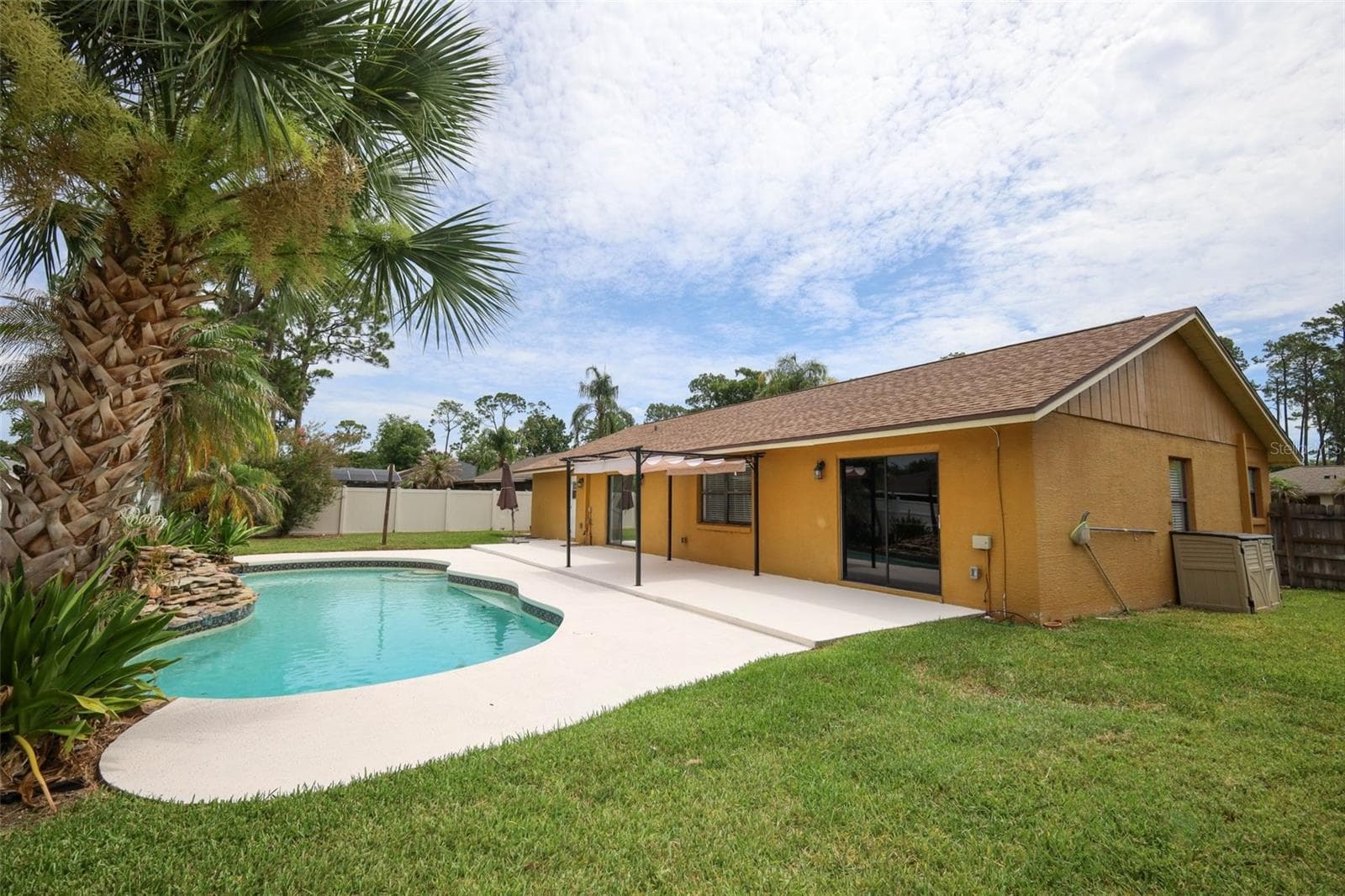Rear yard with an open-air sparkling pool with space for the kids and pets to play. - 9110 PALM TREE DR, WINDERMERE