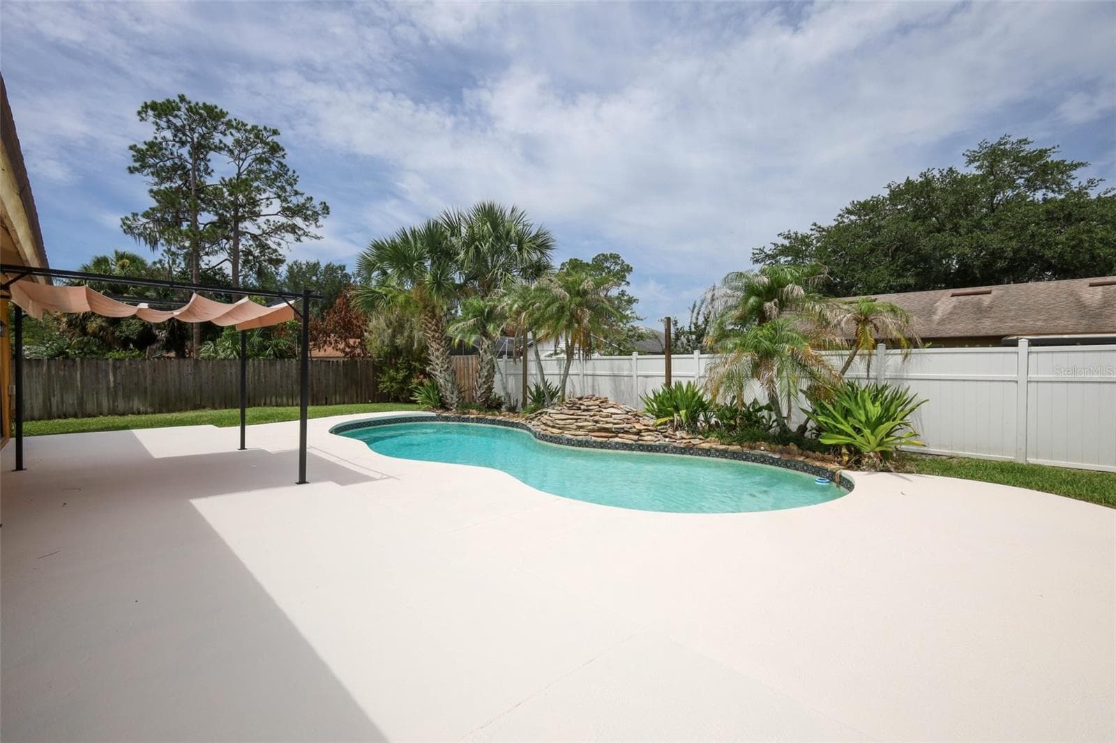 Rear yard with an open-air sparkling pool with space for the kids and pets to play. - 9110 PALM TREE DR, WINDERMERE