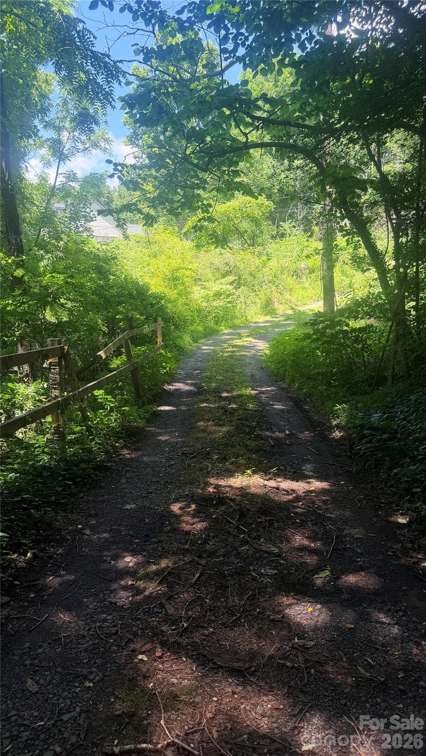 Property starts beyond wooden fence on left. - Asheville
