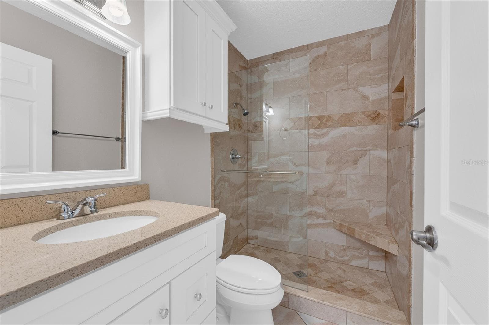 Guest bath with walk-in shower and beautiful travertine tile work - 110 N TREMAIN ST #209, MOUNT DORA