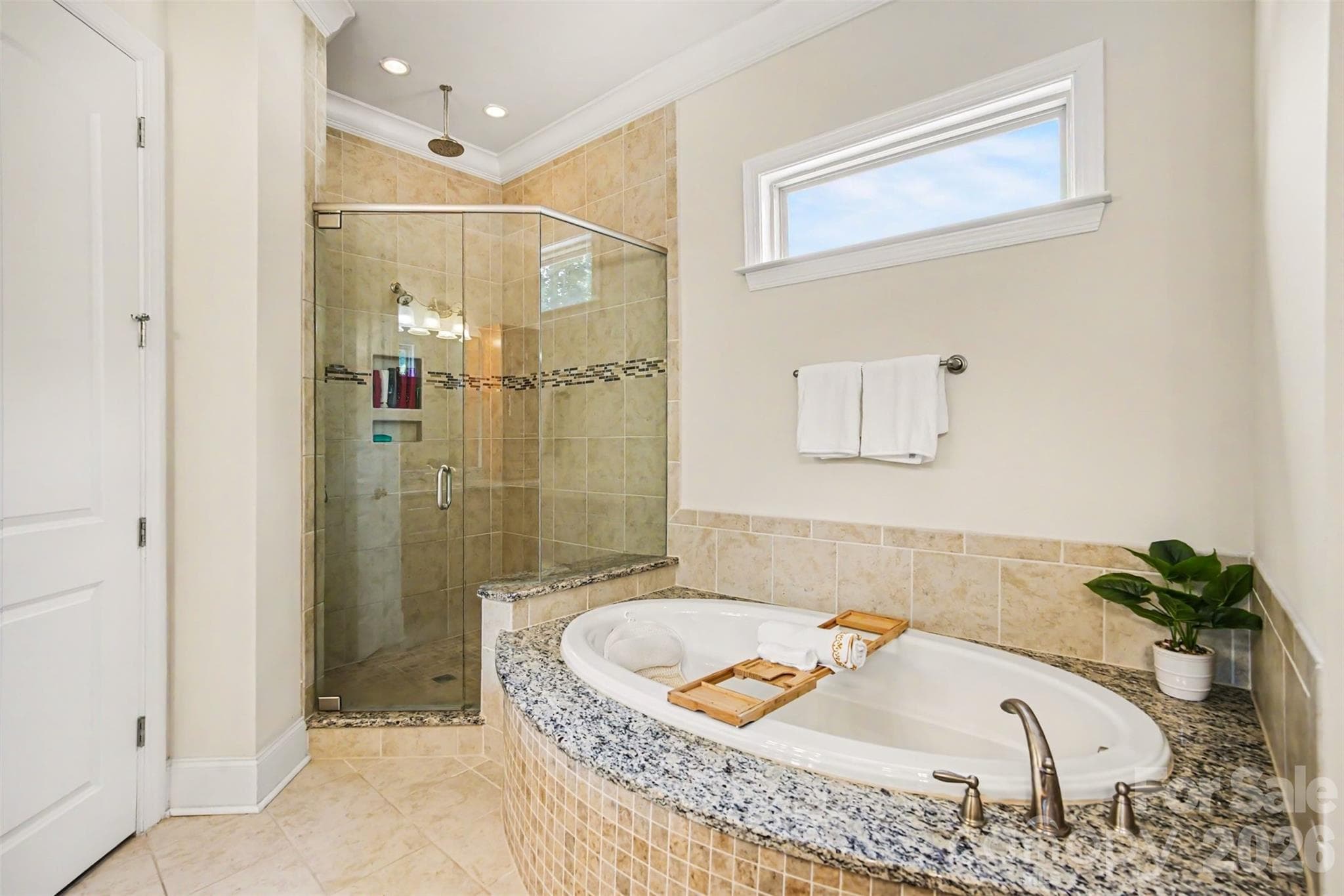 Tile shower and garden tub with beautiful neutral tile and window for natural light. - 3605 Jumprock Road, Indian Land