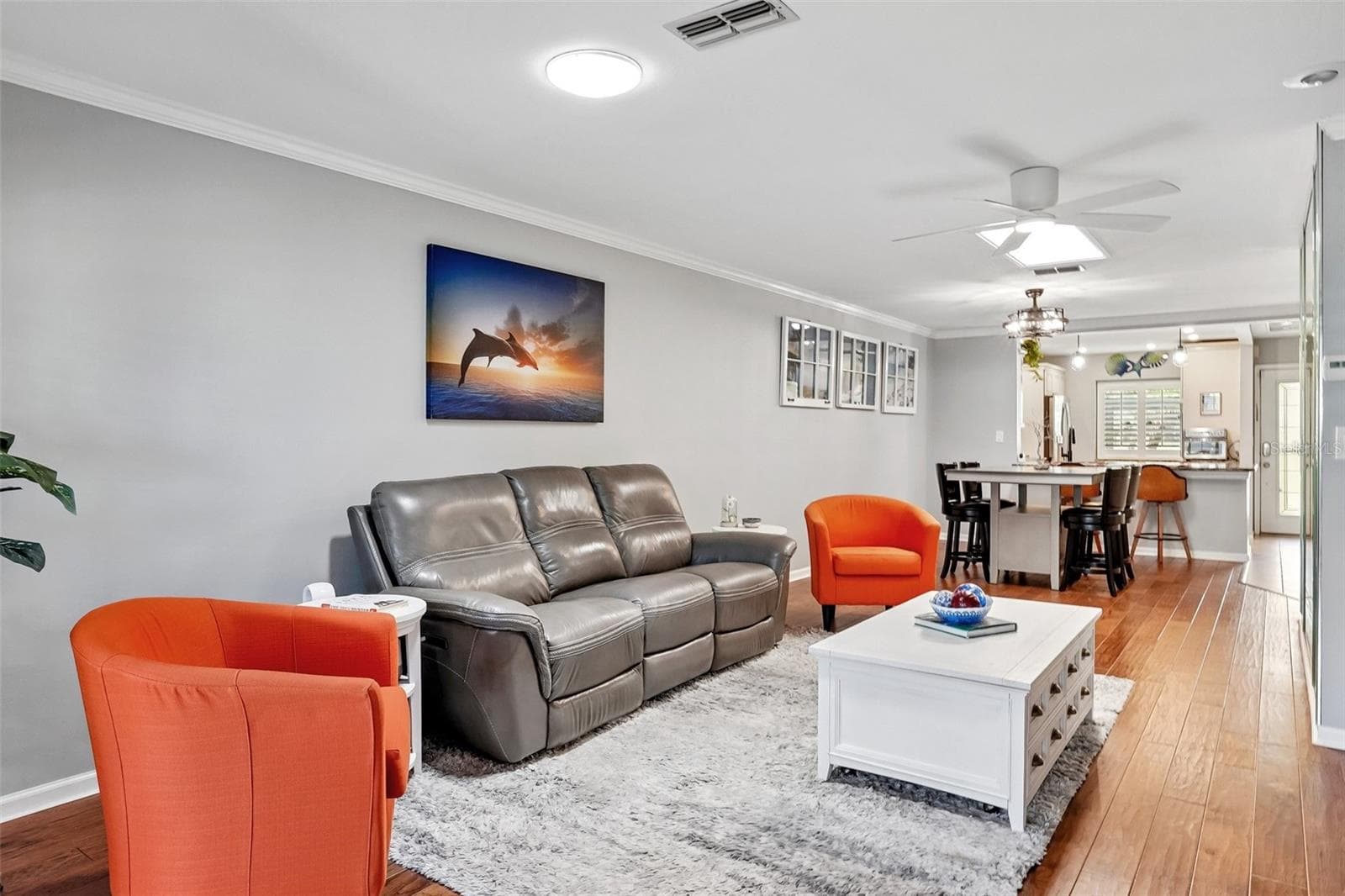 Living room dining room with beautiful engineered hardwood flooring, A travertine accent wall, and LumaDome lighing. - 3259 HILARY CIR #1C, PALM HARBOR