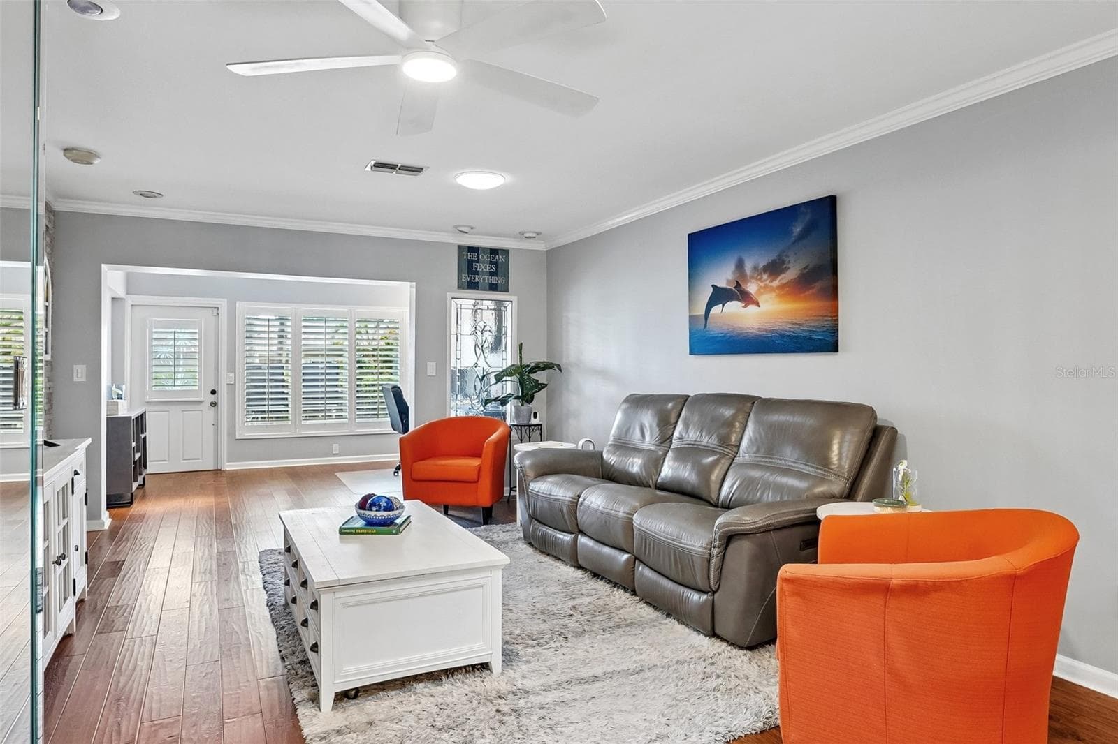 Living room dining room with beautiful engineered hardwood flooring, A travertine accent wall, and LumaDome lighing extends out to sunroom / flex space. - 3259 HILARY CIR #1C, PALM HARBOR
