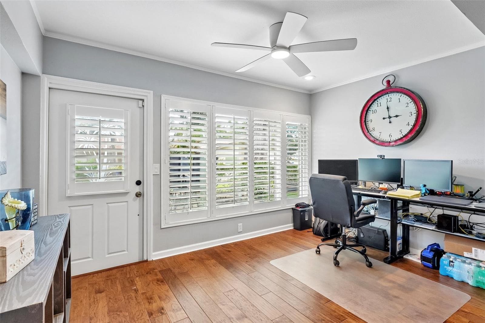 Sunroom / flex space with wall of windows dressed with Key West style plantation shutters is ideal for office, morning coffee, reading or just relaxing. - 3259 HILARY CIR #1C, PALM HARBOR