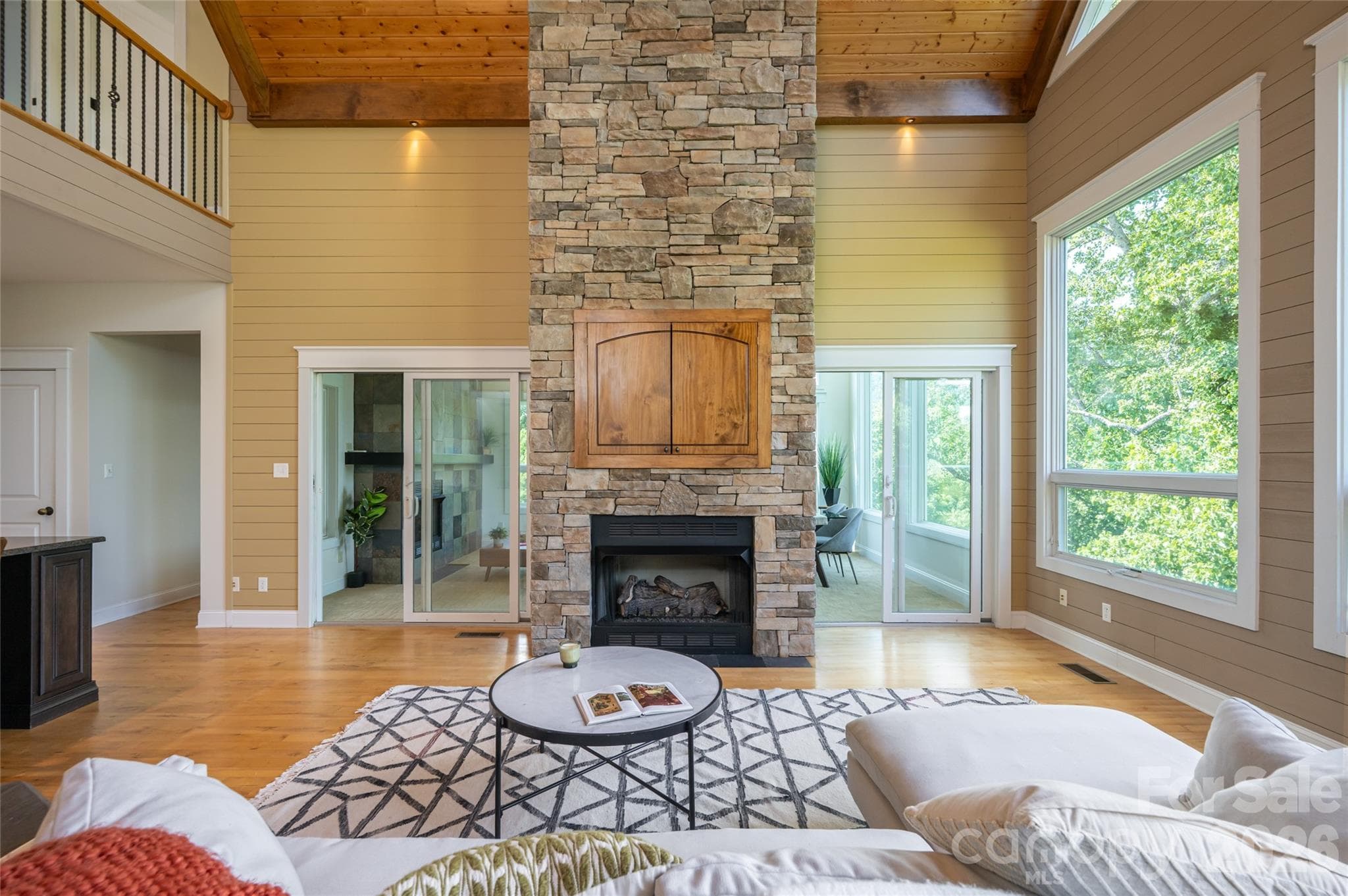 The stacked stone fireplace offers a hideway for a mounted TV - 33 Bridle Path Drive, Barnardsville
