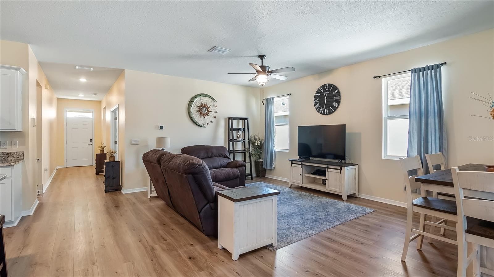 Living room with two windows that provide natural light and new luxury vinyl plank flooring throughout. - 8033 PENROSE PL, WILDWOOD