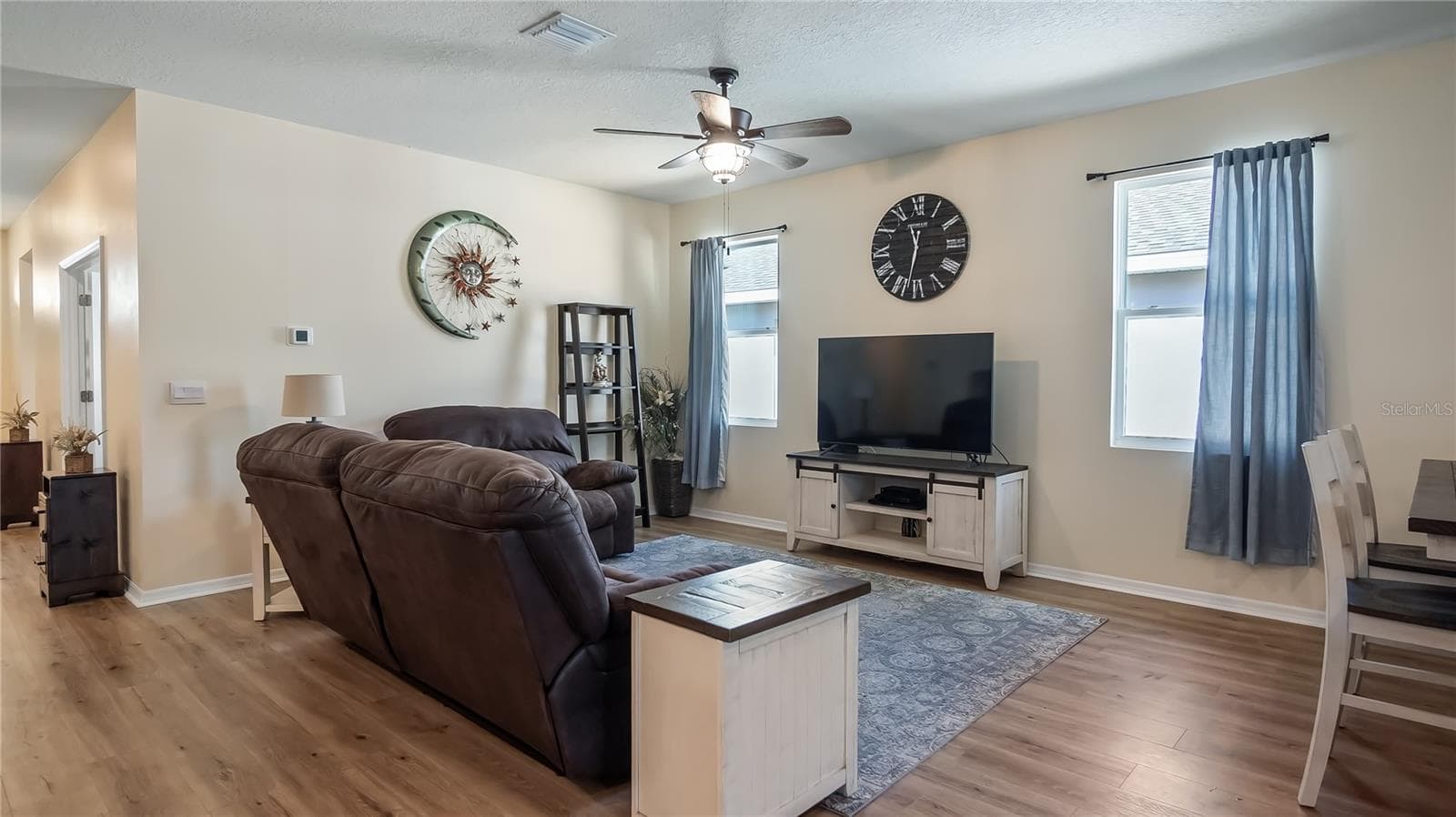 Living room with two windows that provide natural light and new luxury vinyl plank flooring throughout. - 8033 PENROSE PL, WILDWOOD