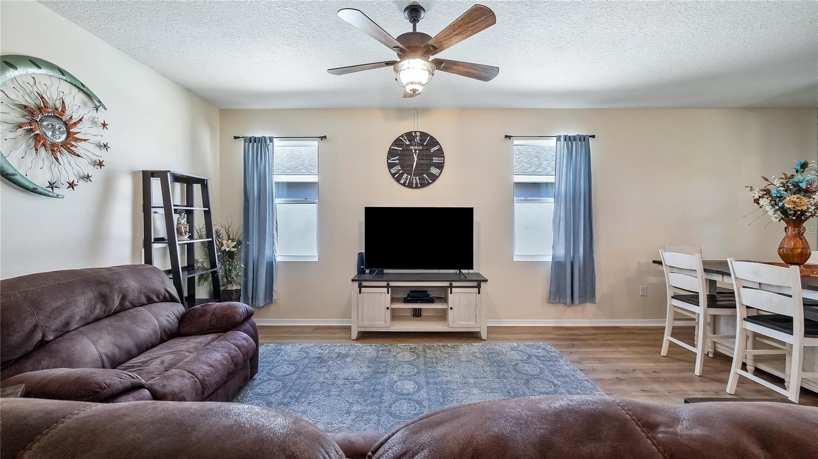 Living room with two windows that provide natural light and new luxury vinyl plank flooring throughout. - 8033 PENROSE PL, WILDWOOD