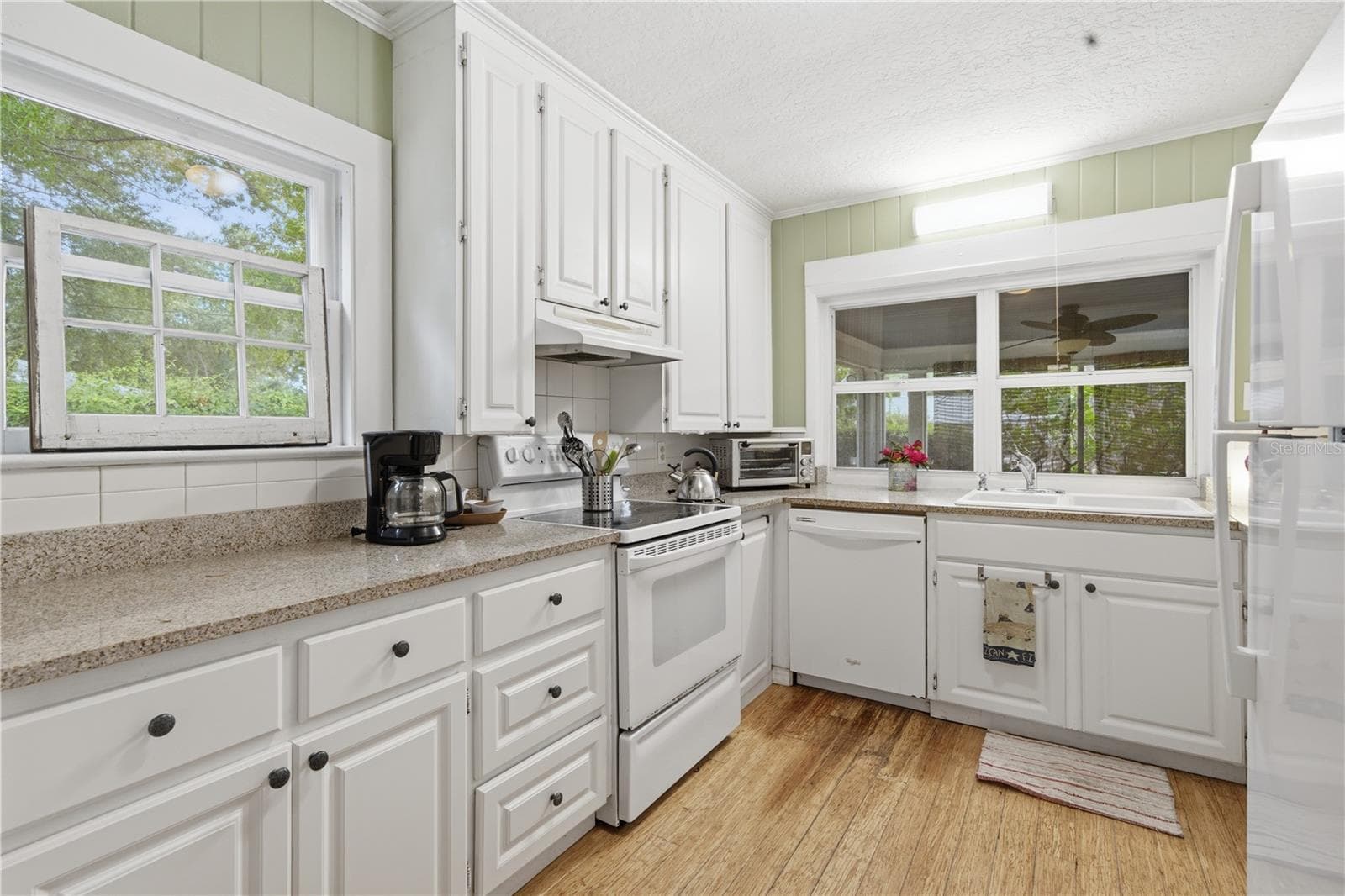 Updated kitchen with stone counters, modern finishes, and luxury vinyl flooring. - 411 W 48TH ST, BRADENTON