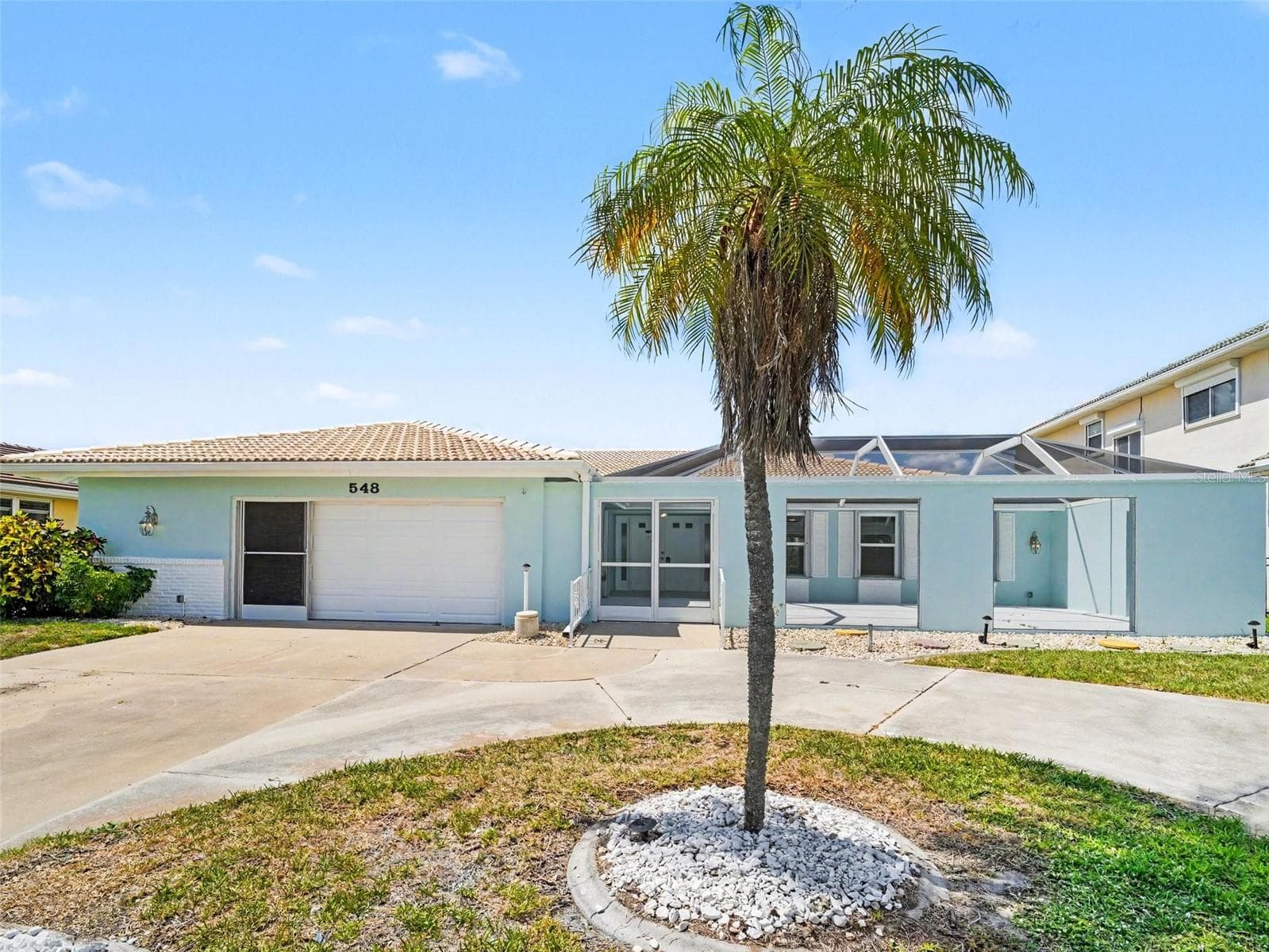 Front of home, oversized garage, large circular drive, expansive screened in court yard - 548 BELVEDERE CT, PUNTA GORDA
