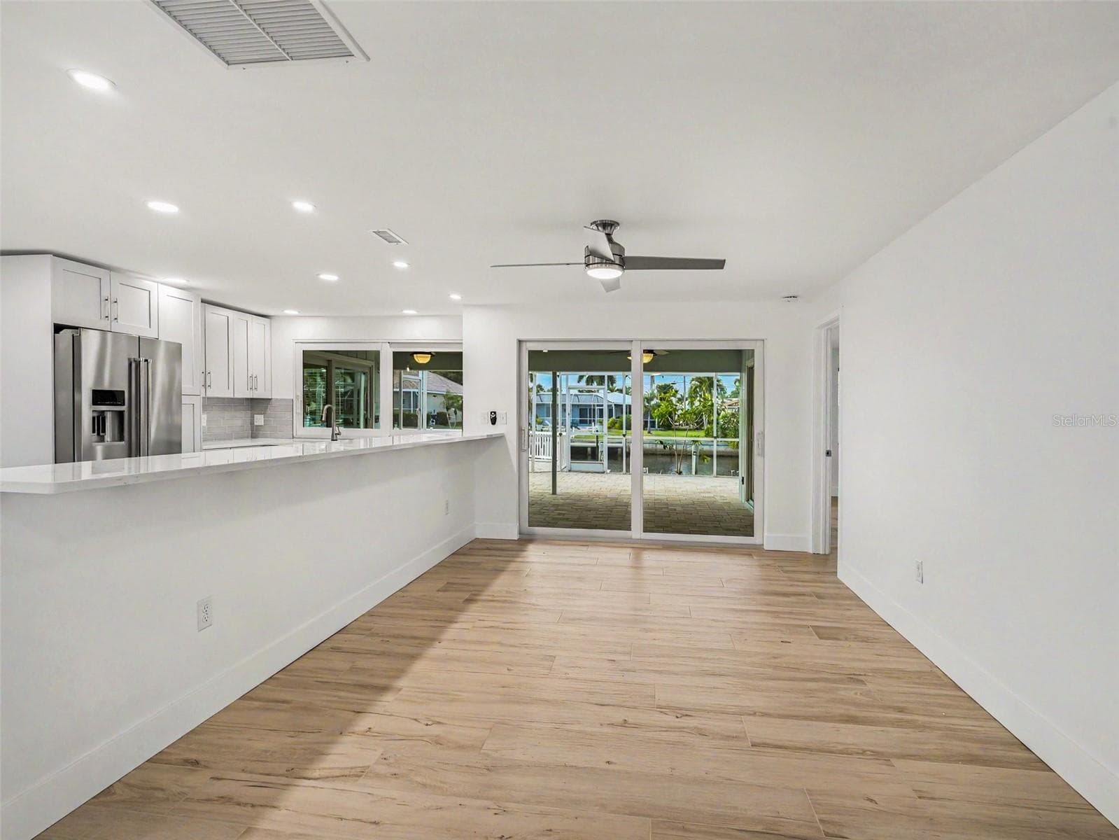 Dining room with ceiling fan, primary bed/bath off to the back right - 548 BELVEDERE CT, PUNTA GORDA