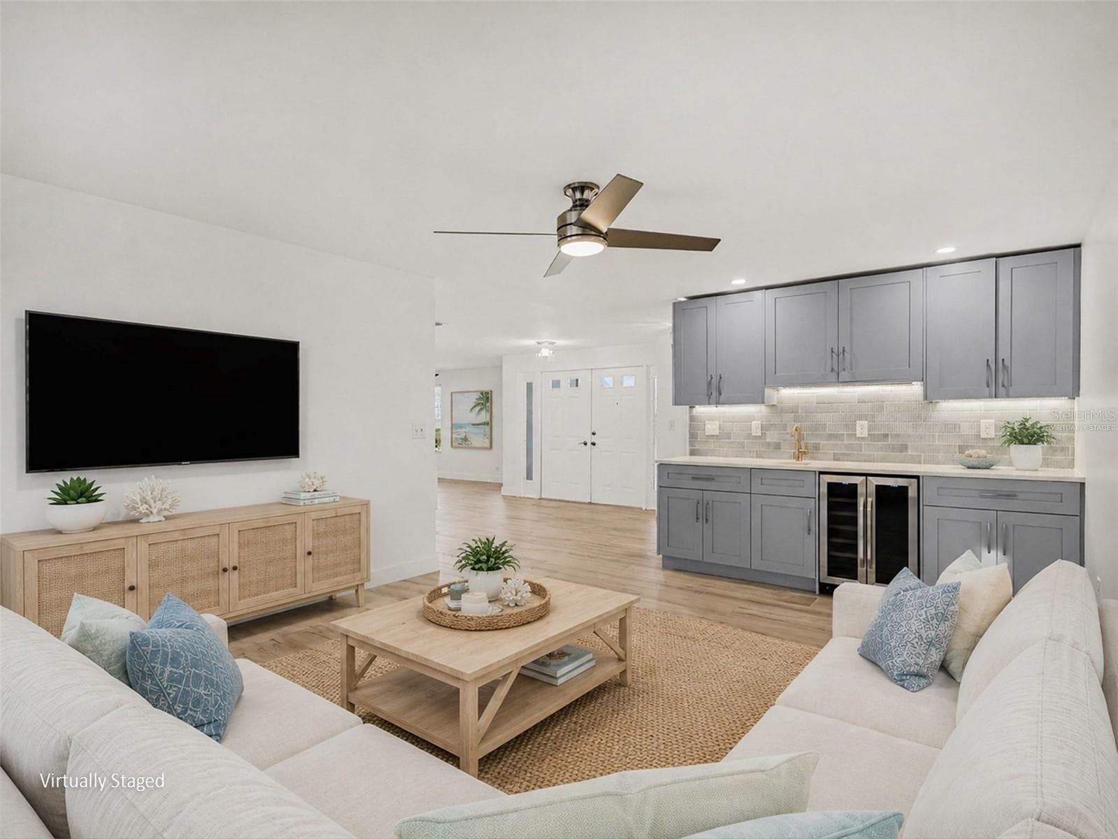Family room virtually staged, looking at wet bar and front foyer - 548 BELVEDERE CT, PUNTA GORDA