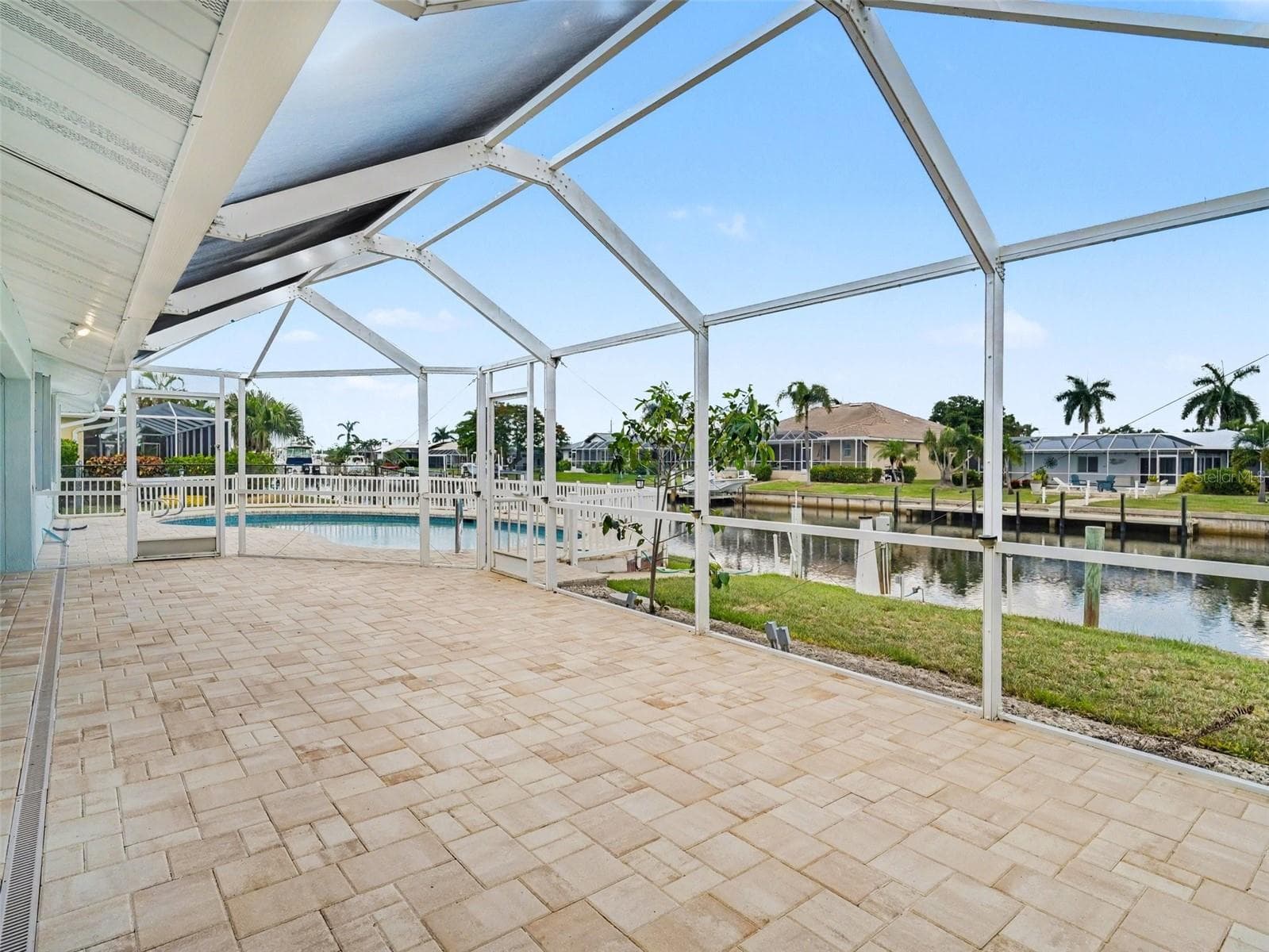 Back lanai extends out another 32 x 13 feet of screened in sun/lounging area overlooking the pool and canal - 548 BELVEDERE CT, PUNTA GORDA