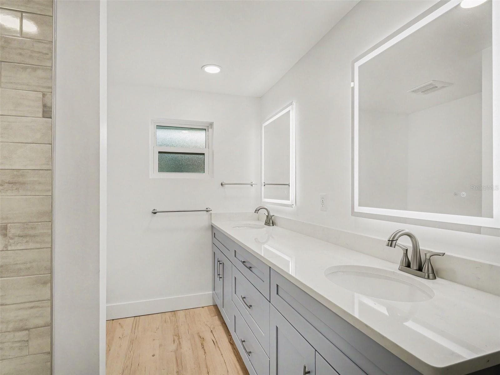 Second bathroom between bedrooms 2 & 3, with lots of cabinetry, shower/tub, linen closet in hallway - 548 BELVEDERE CT, PUNTA GORDA