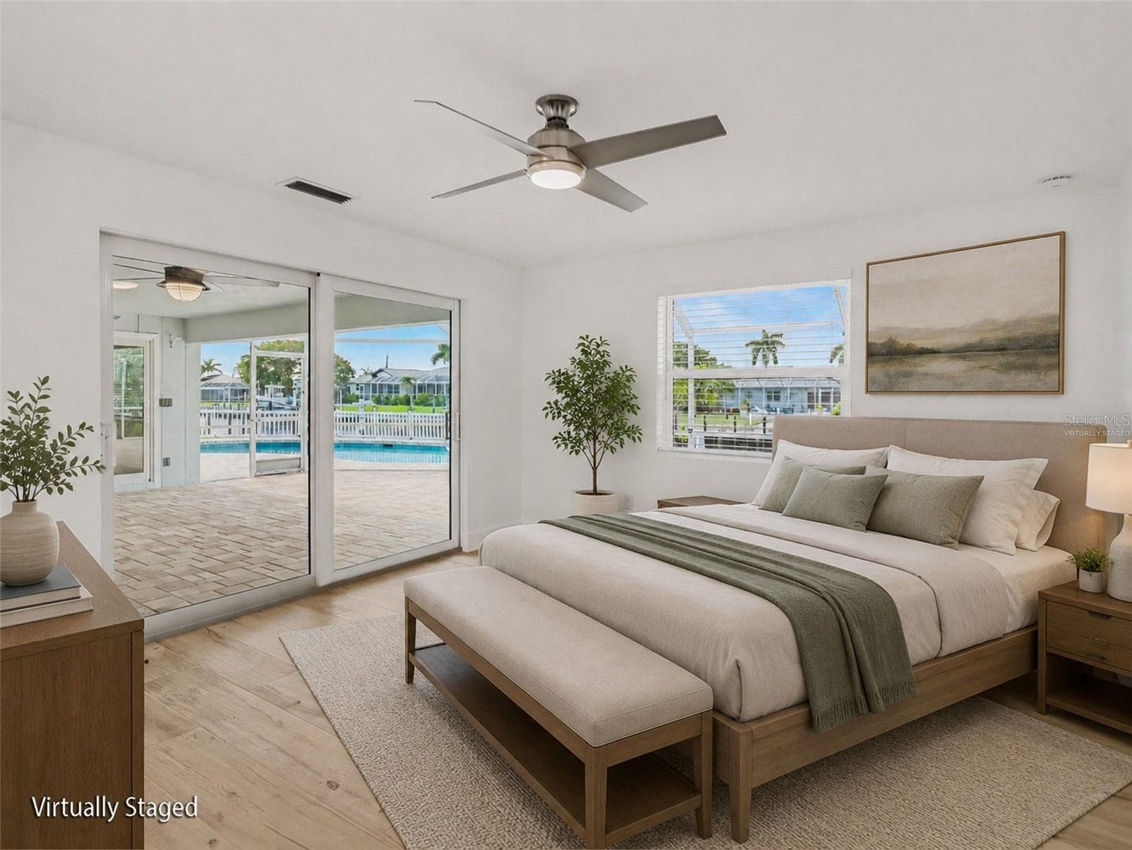 Primary bedroom with ensuite bath overlooking back lanai, pool and water (virtually staged) - 548 BELVEDERE CT, PUNTA GORDA