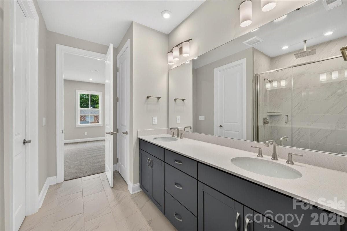 Dual vanity Primary bathroom with rich grey cabinets and white quartz countertops - 232 Old Town Village Road, Waxhaw