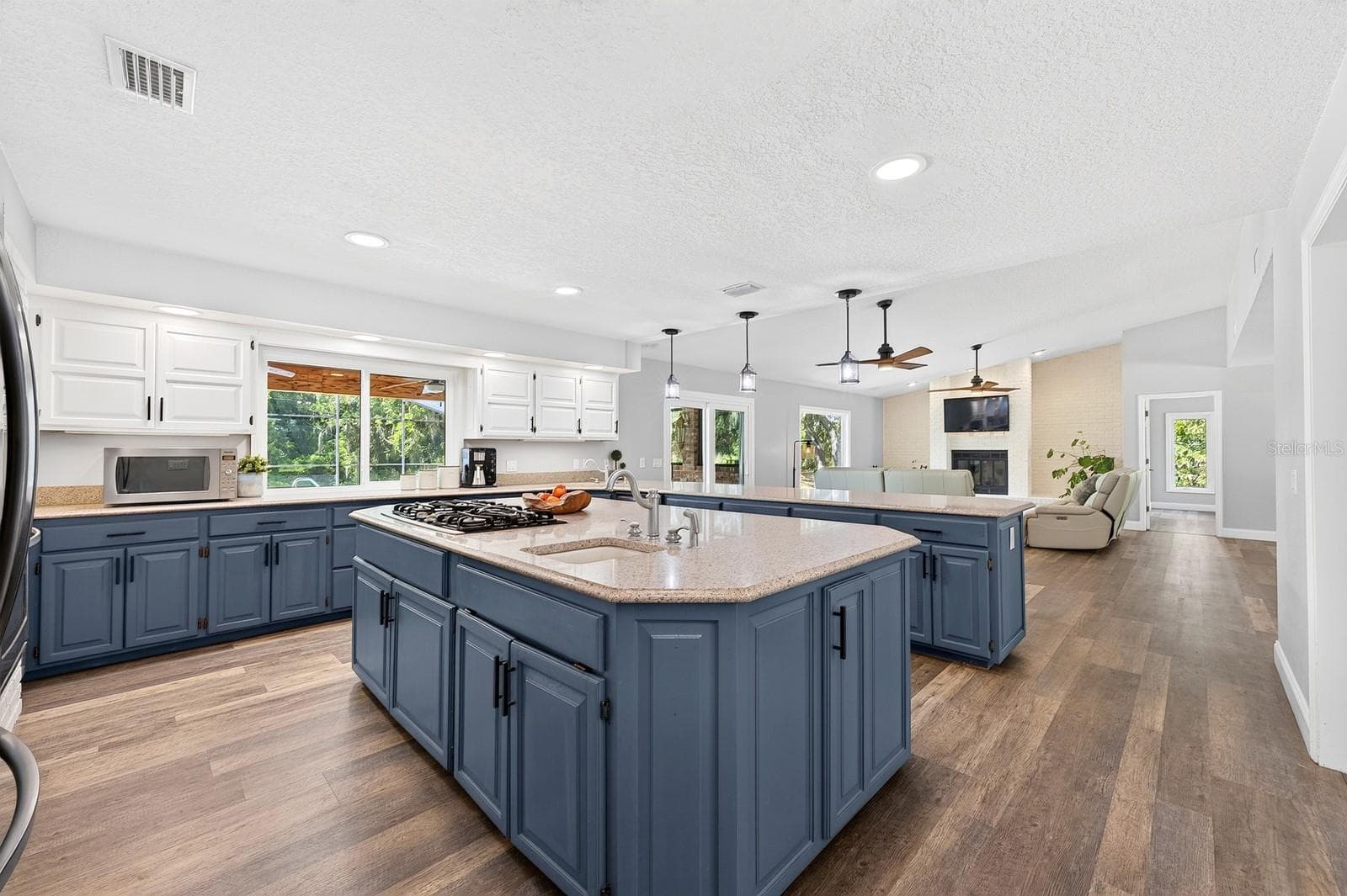 The large center island features a gas cooktop. - 1600 E 10TH ST, ST CLOUD