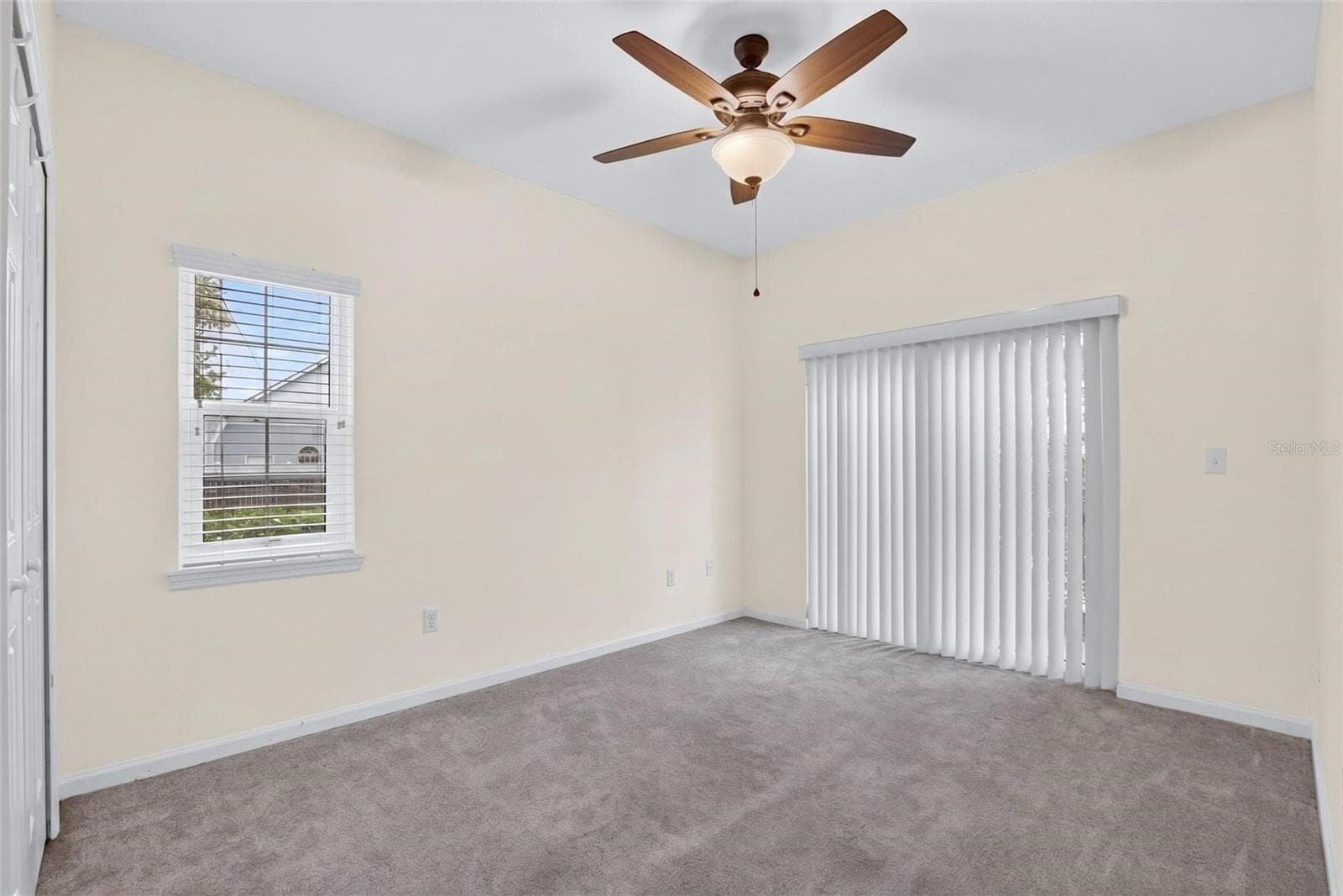 Downstairs bedroom 1 with sliding glass door to patio. - 307 SUMMER CLOUDS PL, BRANDON