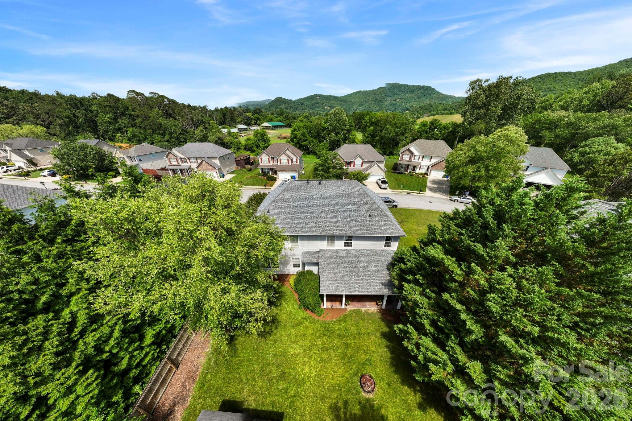 Wide aerial view capturing the neighborhood layout, nearby greenways, and beautiful mountain vistas that define the area. - Fletcher