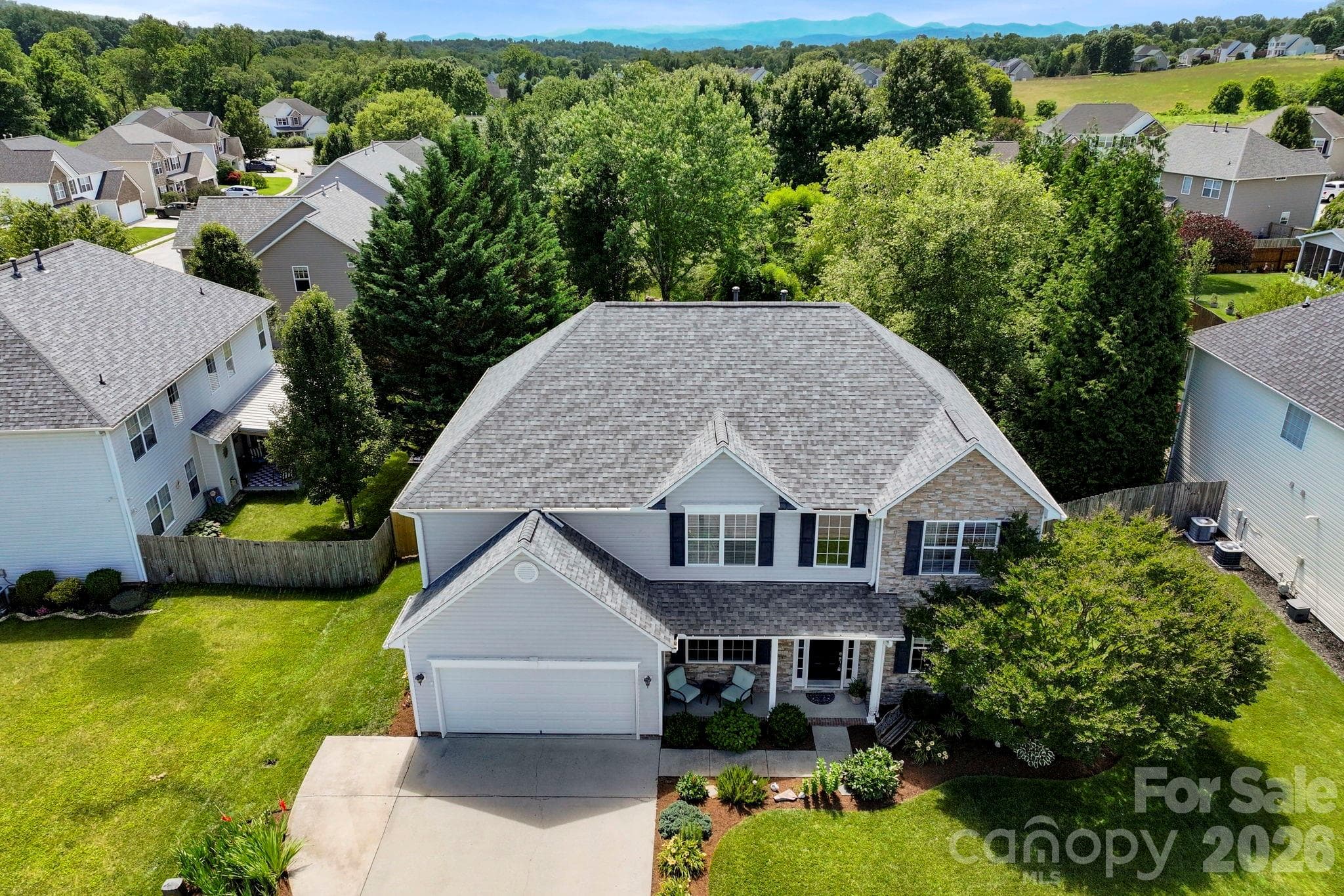 Overhead aerial view showcasing the home's footprint, fenced backyard, outdoor living spaces, and surrounding neighborhood. - Fletcher