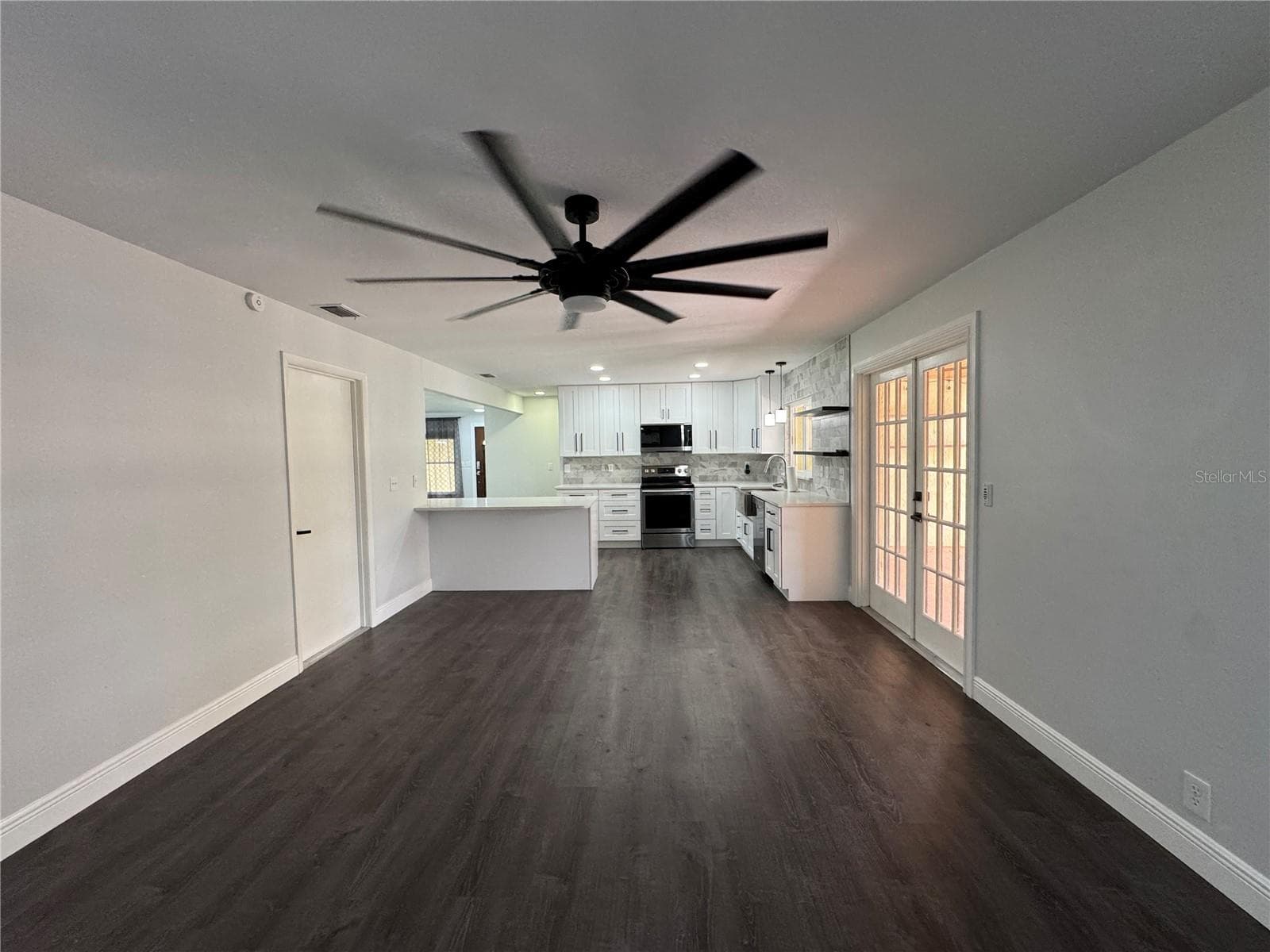 This image features a large, spacious family room designed for comfort and entertainment, offering an open floor plan that flows seamlessly into the rest of the home. - 1809 STELLA CT N, LAKELAND