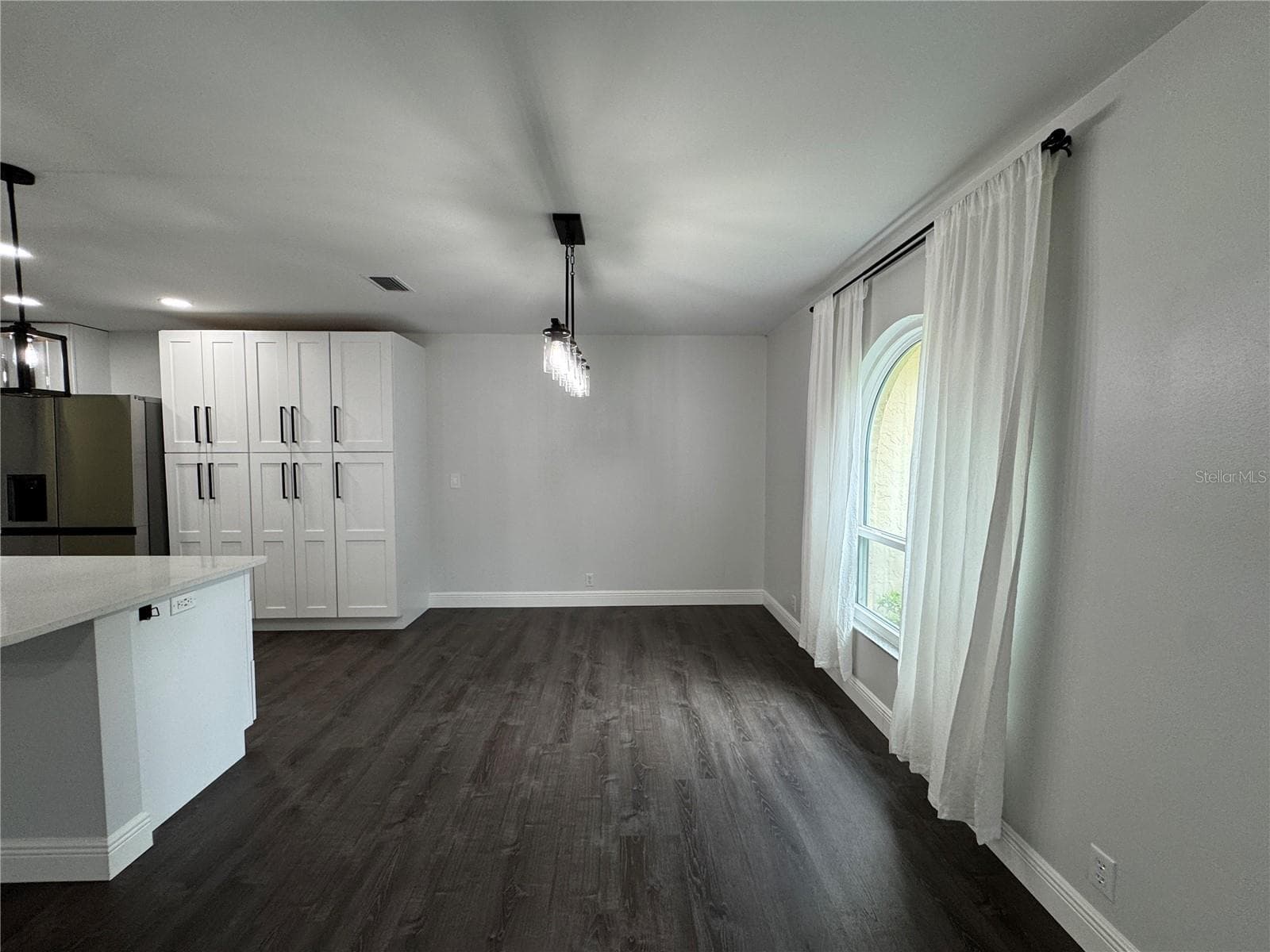 This is a bright and airy dining room featuring a large window that allows for an abundance of natural light, perfect for entertaining and family meals. - 1809 STELLA CT N, LAKELAND