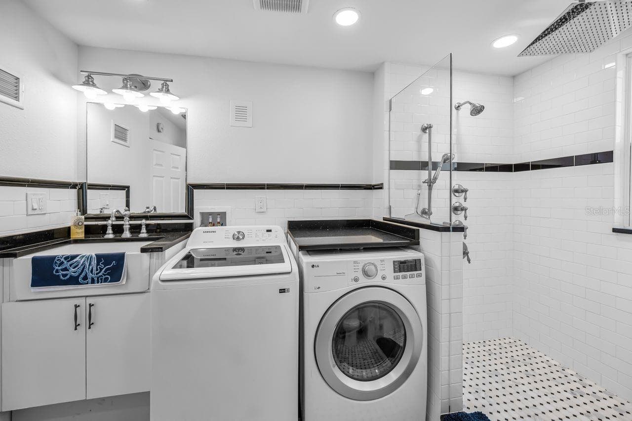 Upstairs laundry room with a full guest bath. - 732 NE OAK ST, ST PETERSBURG