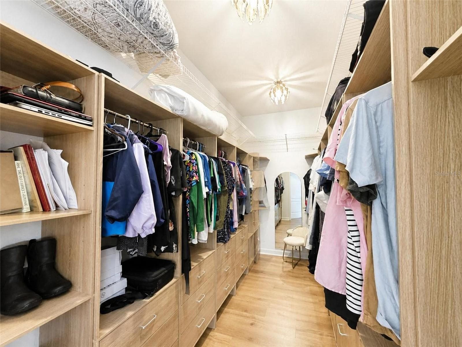 Designer walk-in dressing room featuring custom shelving, double hanging areas, and abundant storage. - 915 N CROOKED LAKE DR, BABSON PARK