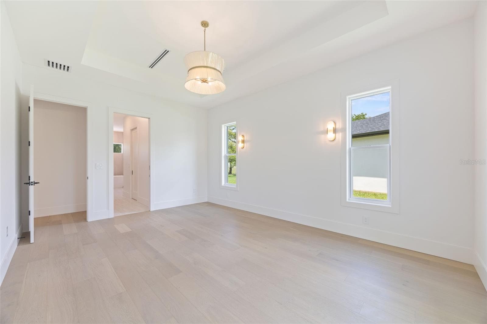 The luxurious primary suite offers a spa-inspired retreat featuring a freestanding soaking tub, oversized walk-in shower with rain head and handheld shower, premium Italian tile, designer fixtures, and thoughtful custom details throughout. - 1336 HAYS RD, TARPON SPRINGS