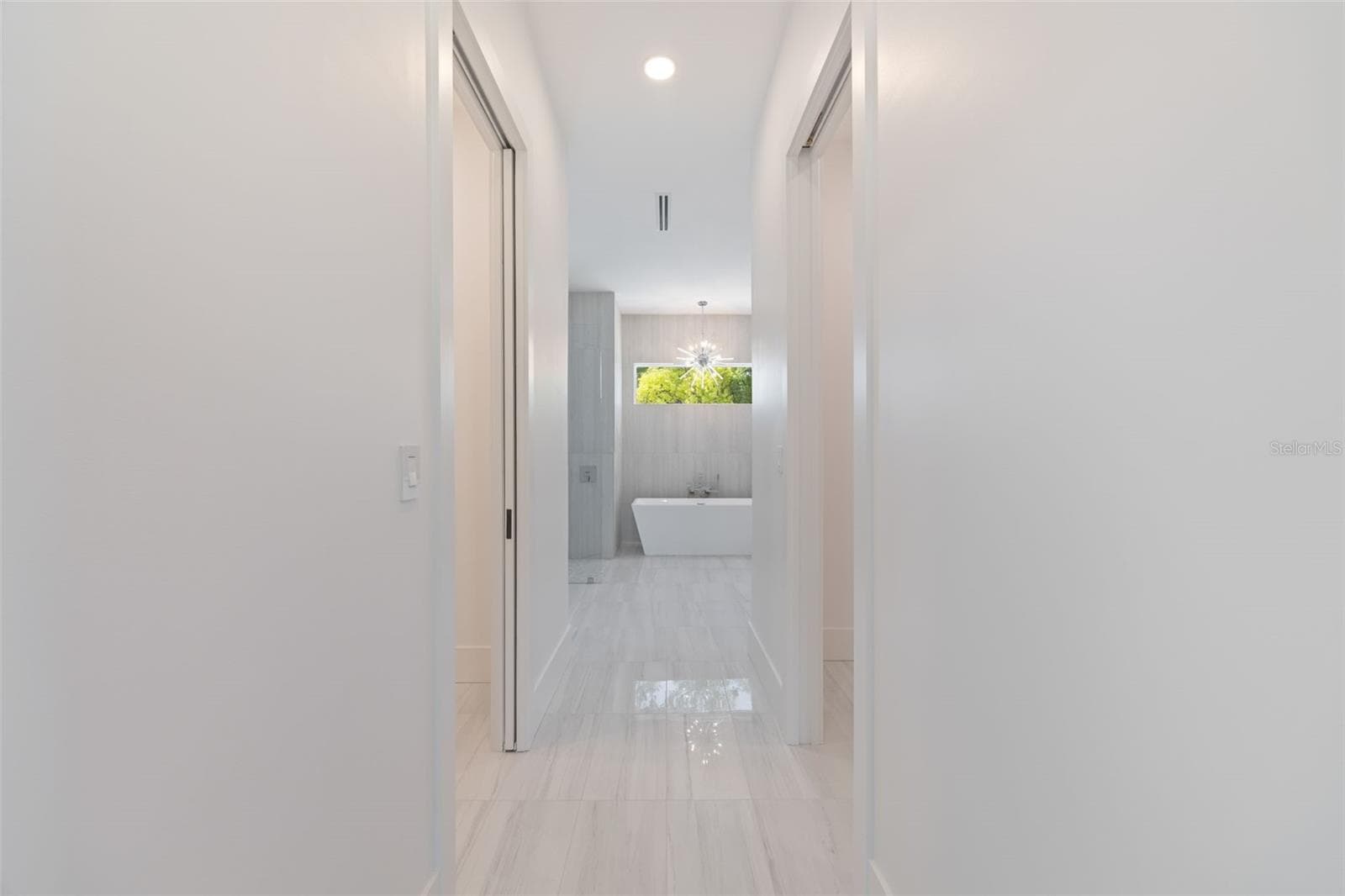 The luxurious primary suite offers a spa-inspired retreat featuring a freestanding soaking tub, oversized walk-in shower with rain head and handheld shower, premium Italian tile, designer fixtures, and thoughtful custom details throughout. - 1336 HAYS RD, TARPON SPRINGS