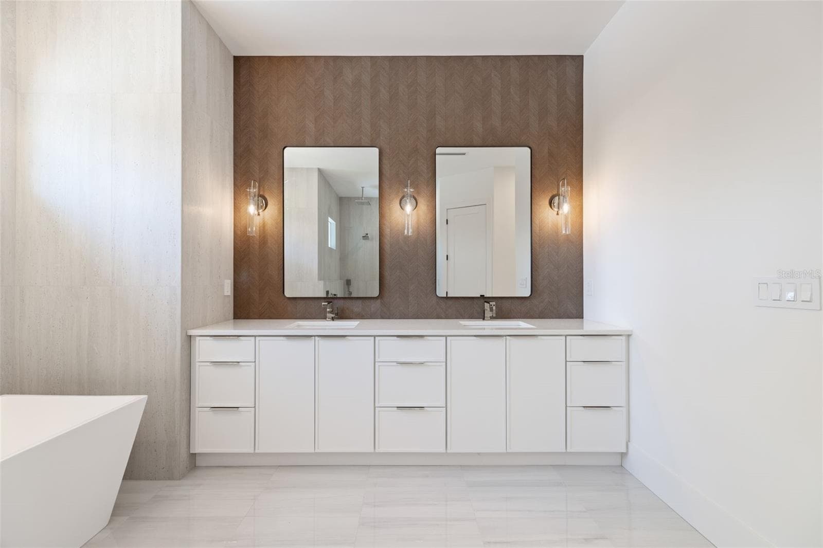 The luxurious primary suite offers a spa-inspired retreat featuring a freestanding soaking tub, oversized walk-in shower with rain head and handheld shower, premium Italian tile, designer fixtures, and thoughtful custom details throughout. - 1336 HAYS RD, TARPON SPRINGS