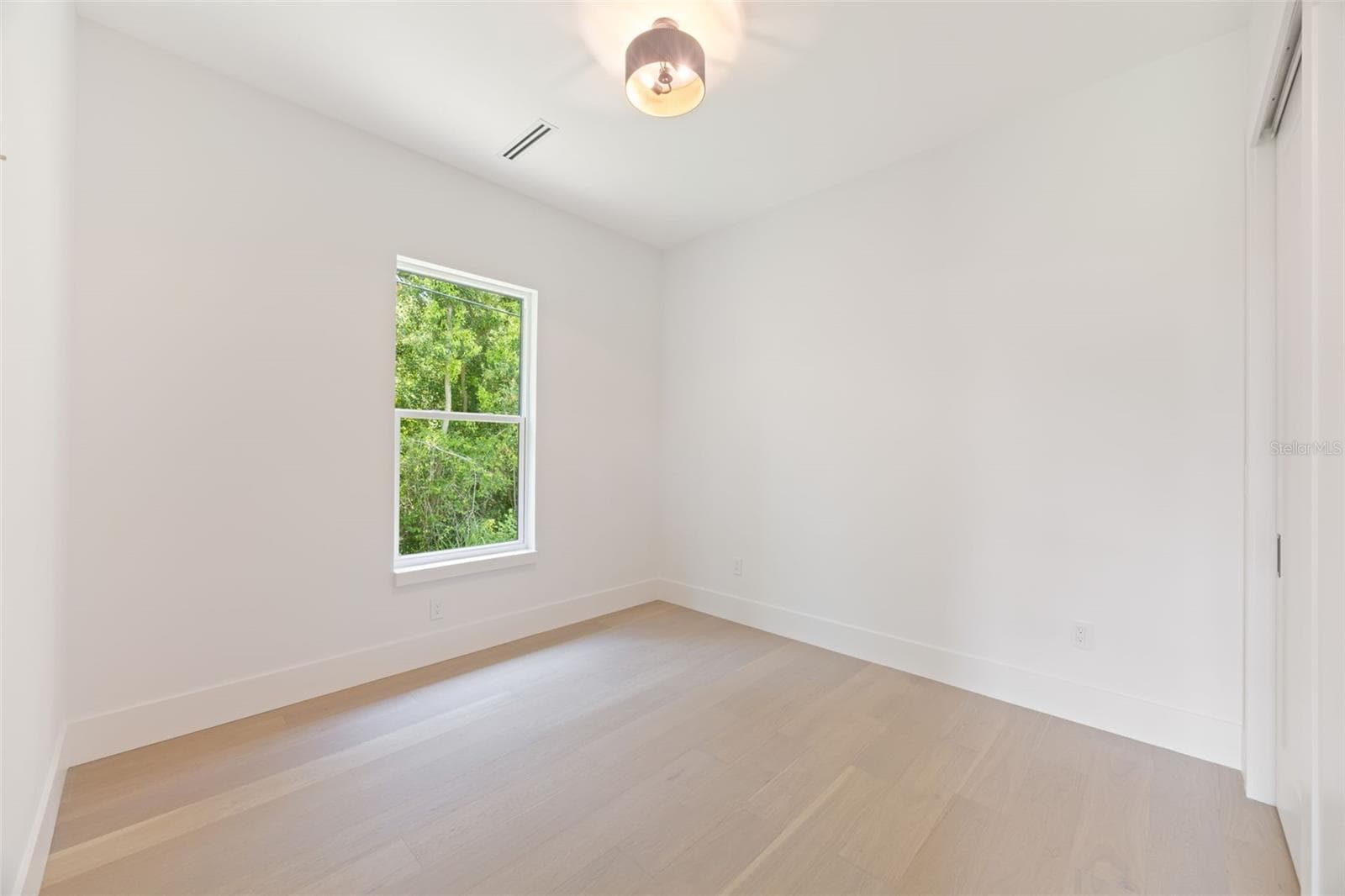 Bedroom 4 enjoys a private en-suite bath with direct exterior access to the lanai, providing an ideal guest retreat and future pool bath. - 1336 HAYS RD, TARPON SPRINGS