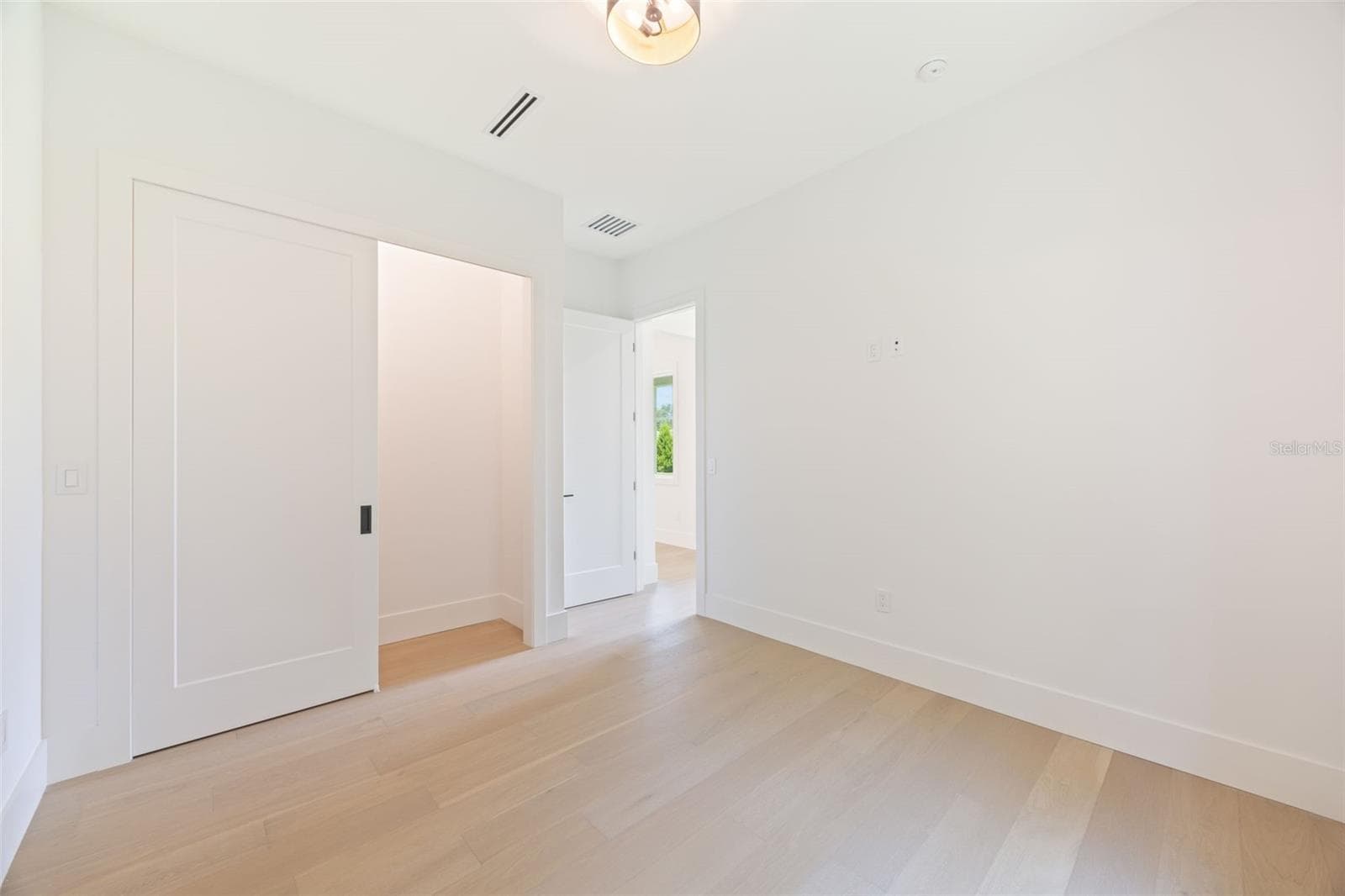 Bedroom 4 enjoys a private en-suite bath with direct exterior access to the lanai, providing an ideal guest retreat and future pool bath. - 1336 HAYS RD, TARPON SPRINGS