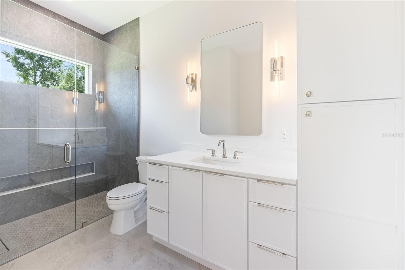 Bedroom 3 enjoys a private en-suite bath with direct exterior access to the lanai, providing an ideal guest retreat and future pool bath. - 1336 HAYS RD, TARPON SPRINGS