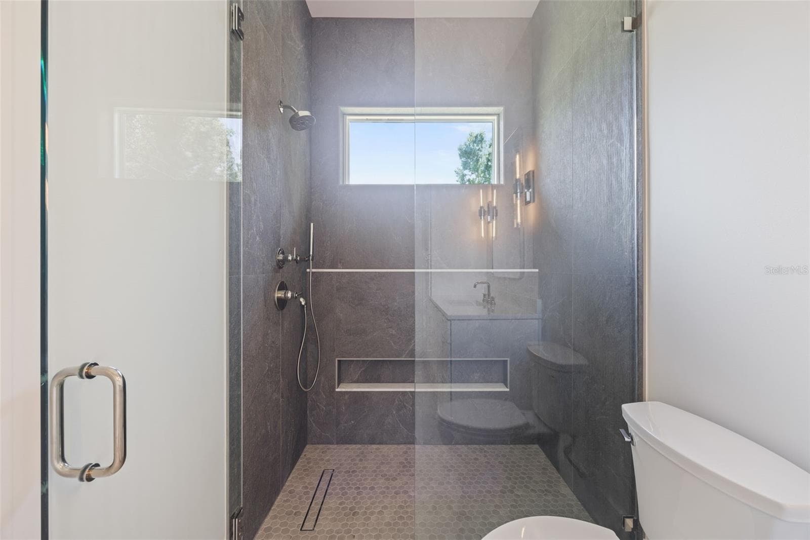 Bedroom 3 enjoys a private en-suite bath with direct exterior access to the lanai, providing an ideal guest retreat and future pool bath. - 1336 HAYS RD, TARPON SPRINGS