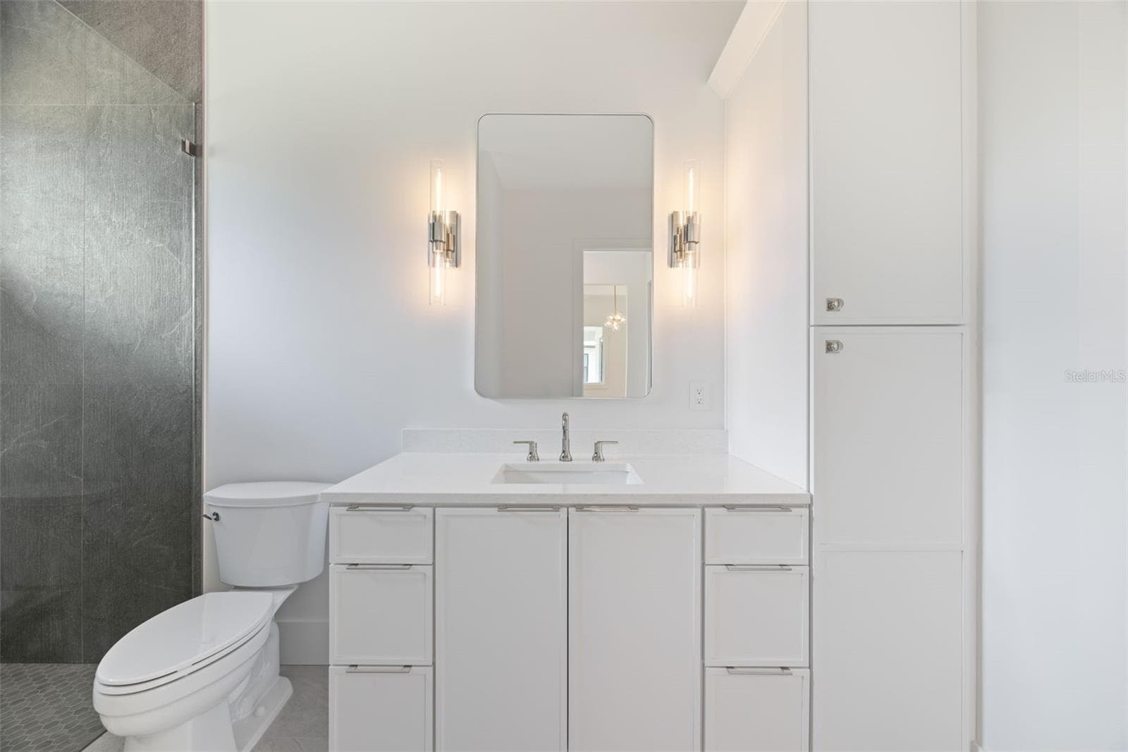 Bedroom 3 enjoys a private en-suite bath with direct exterior access to the lanai, providing an ideal guest retreat and future pool bath. - 1336 HAYS RD, TARPON SPRINGS
