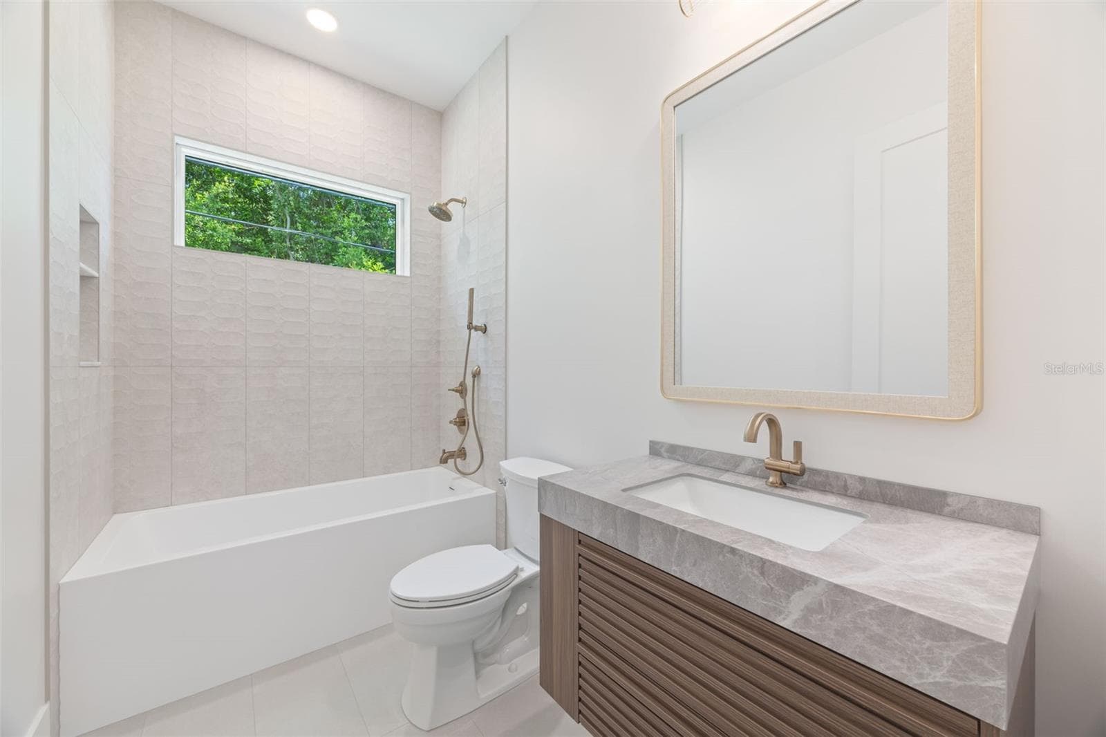 The 2nd full bathroom showcases oversized Italian tile, designer-selected fixtures, and elegant finishes consistent with the home's custom craftsmanship. - 1336 HAYS RD, TARPON SPRINGS