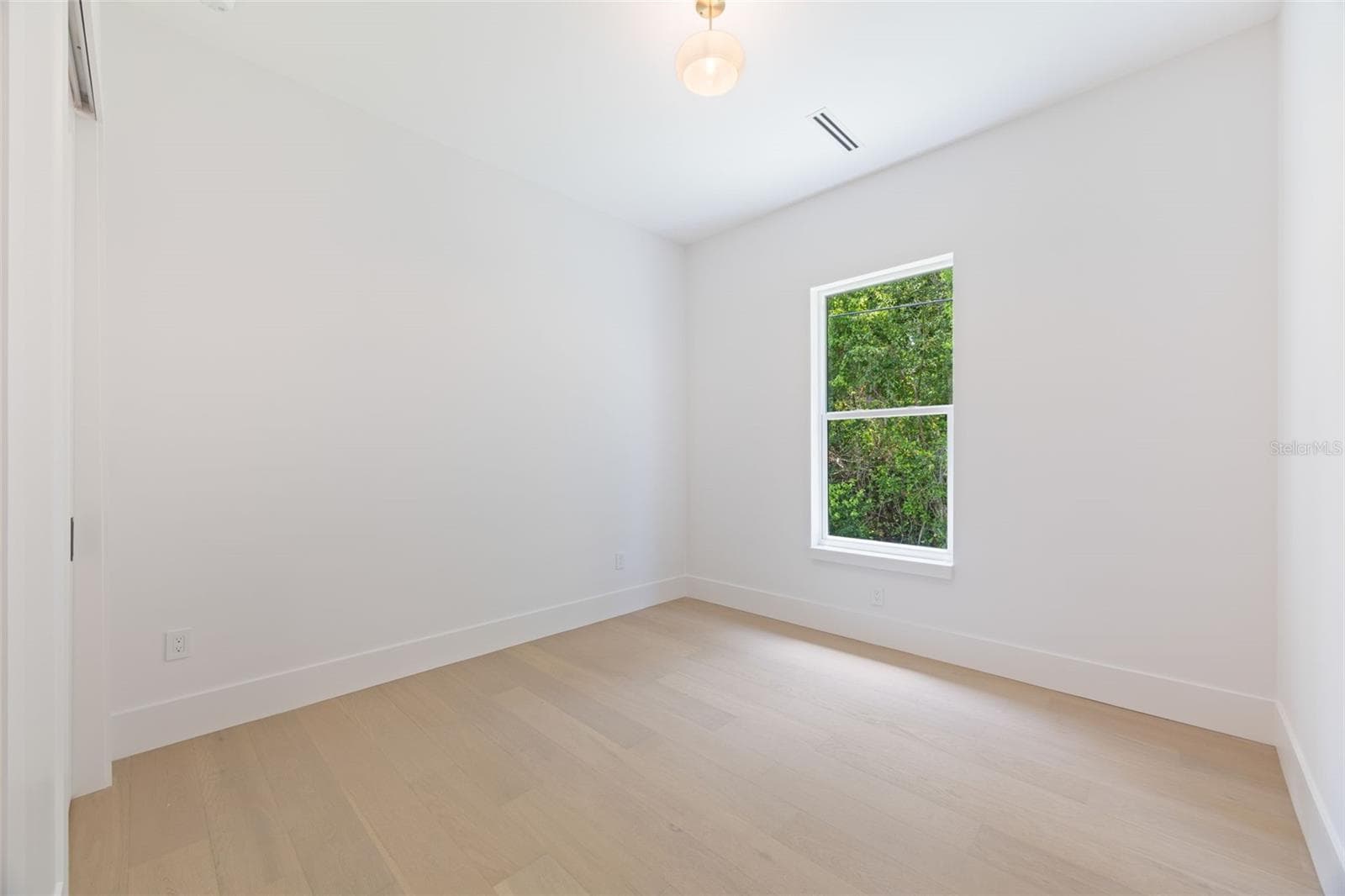 Spacious bedroom 3 with impact-rated window, solid-core door, and convenient access to a full bath. - 1336 HAYS RD, TARPON SPRINGS