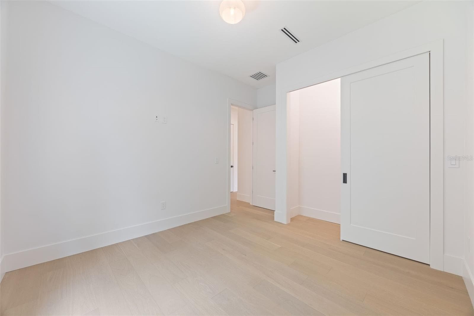 Spacious bedroom 3 with impact-rated window, solid-core door, and convenient access to a full bath. - 1336 HAYS RD, TARPON SPRINGS
