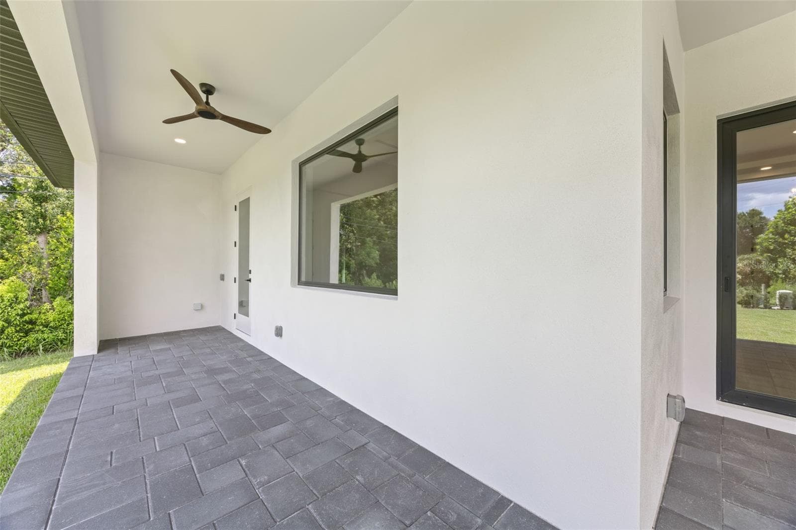 Covered paver lanai, pre-plumbed for a future outdoor kitchen, overlooking the beautifully landscaped yard with premium St. Augustine sod and mature native pine trees. - 1336 HAYS RD, TARPON SPRINGS